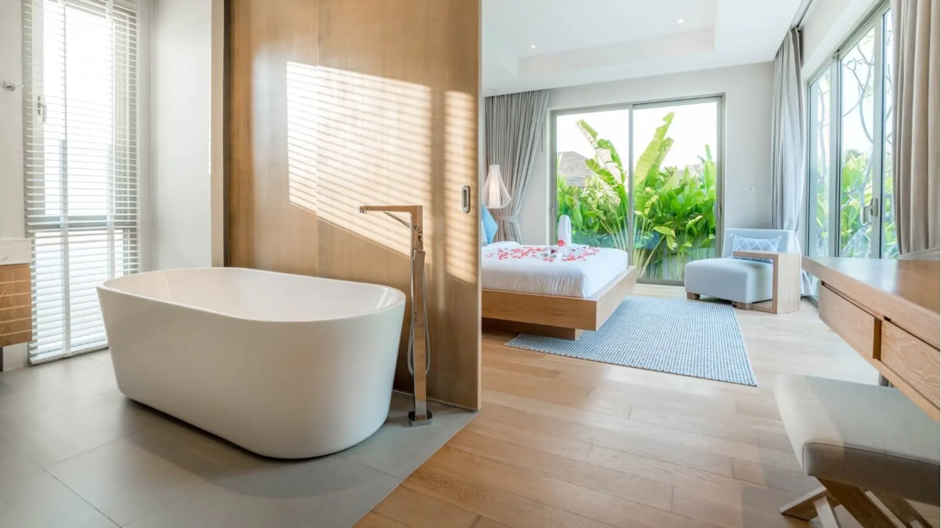 Eine Badewanne hinter einer halben Trennwand.