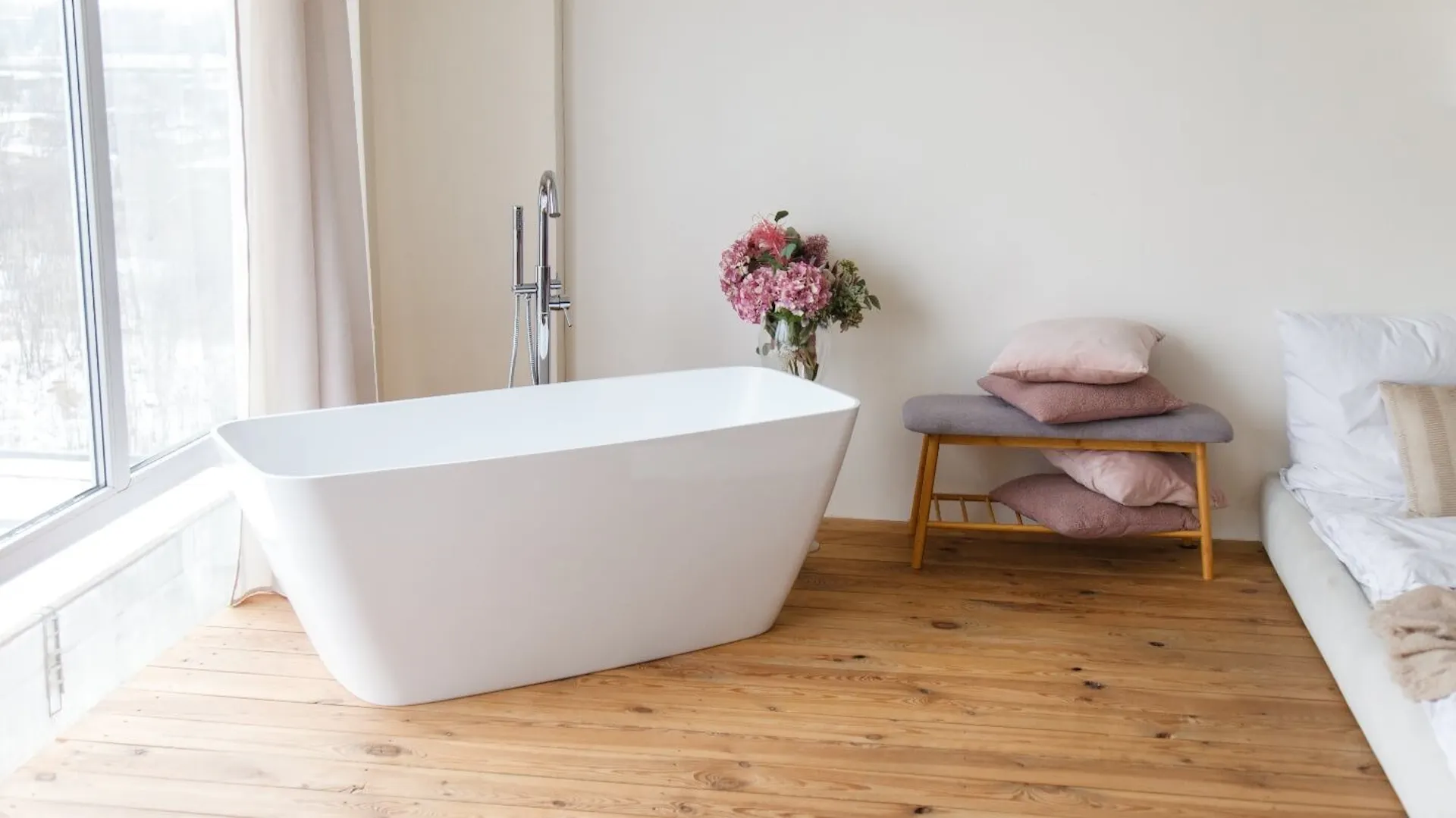 Eine Badewanne neben einem Bett.