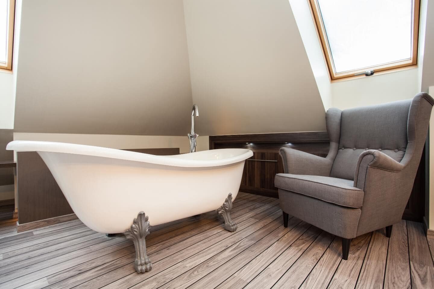 Eine Badewanne mit einem Sessel im Dachgeschoss.