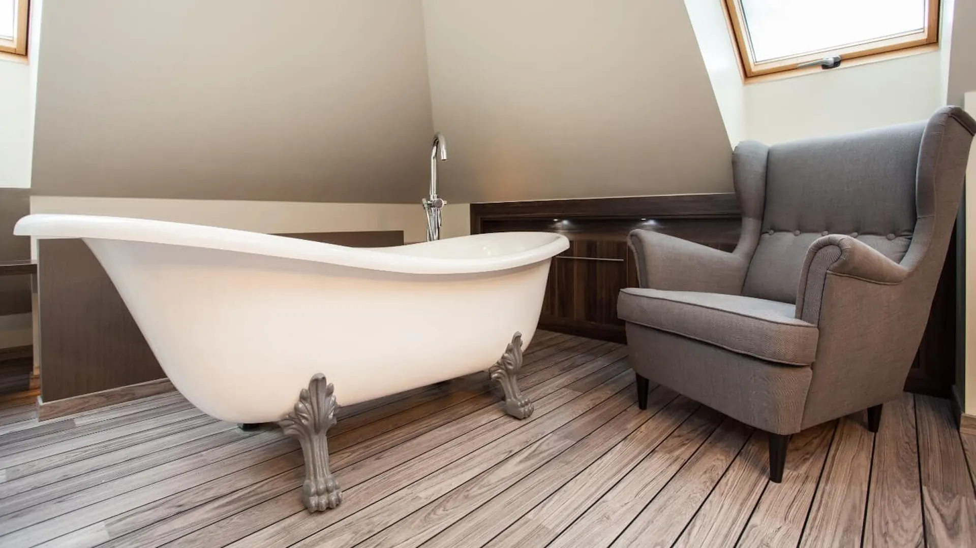 Eine Badewanne mit einem Sessel im Dachgeschoss.