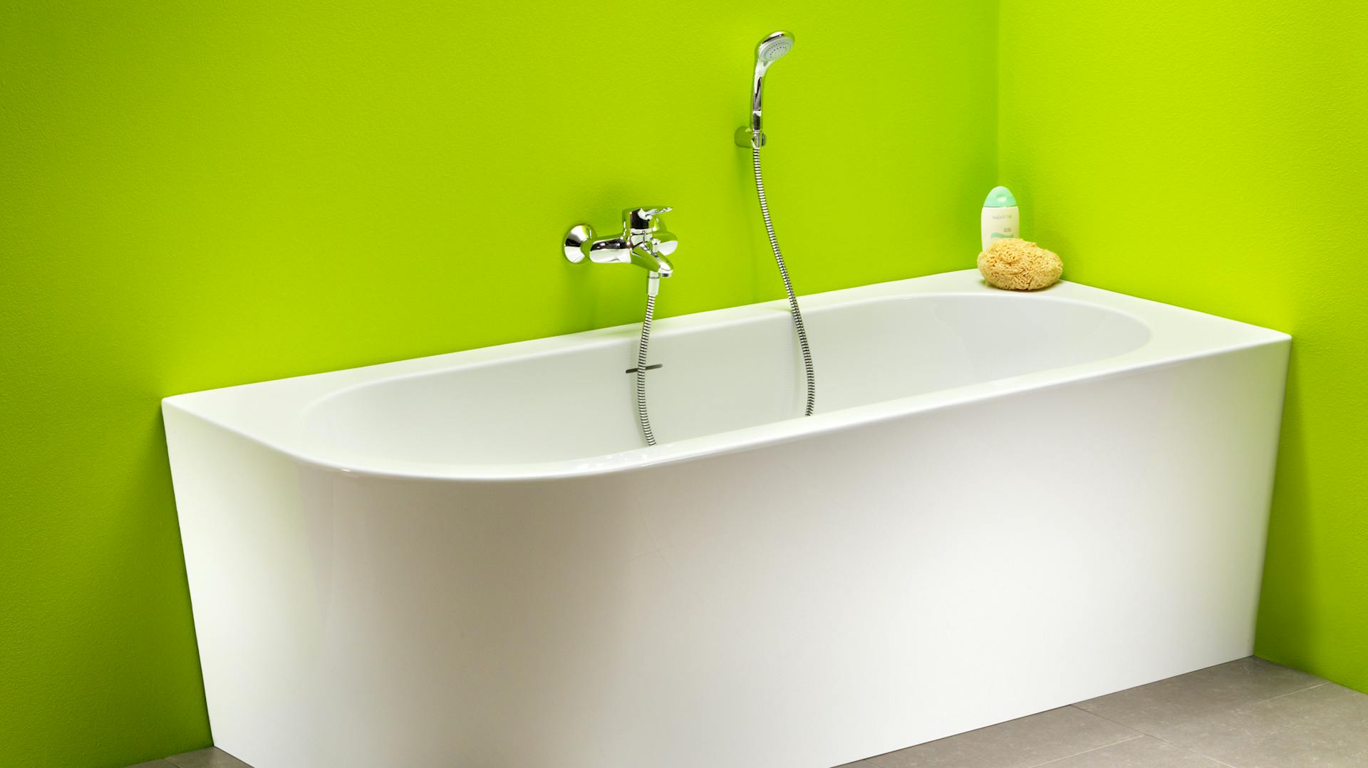 Eckbadewanne für Schlauchbad an grüner Wand