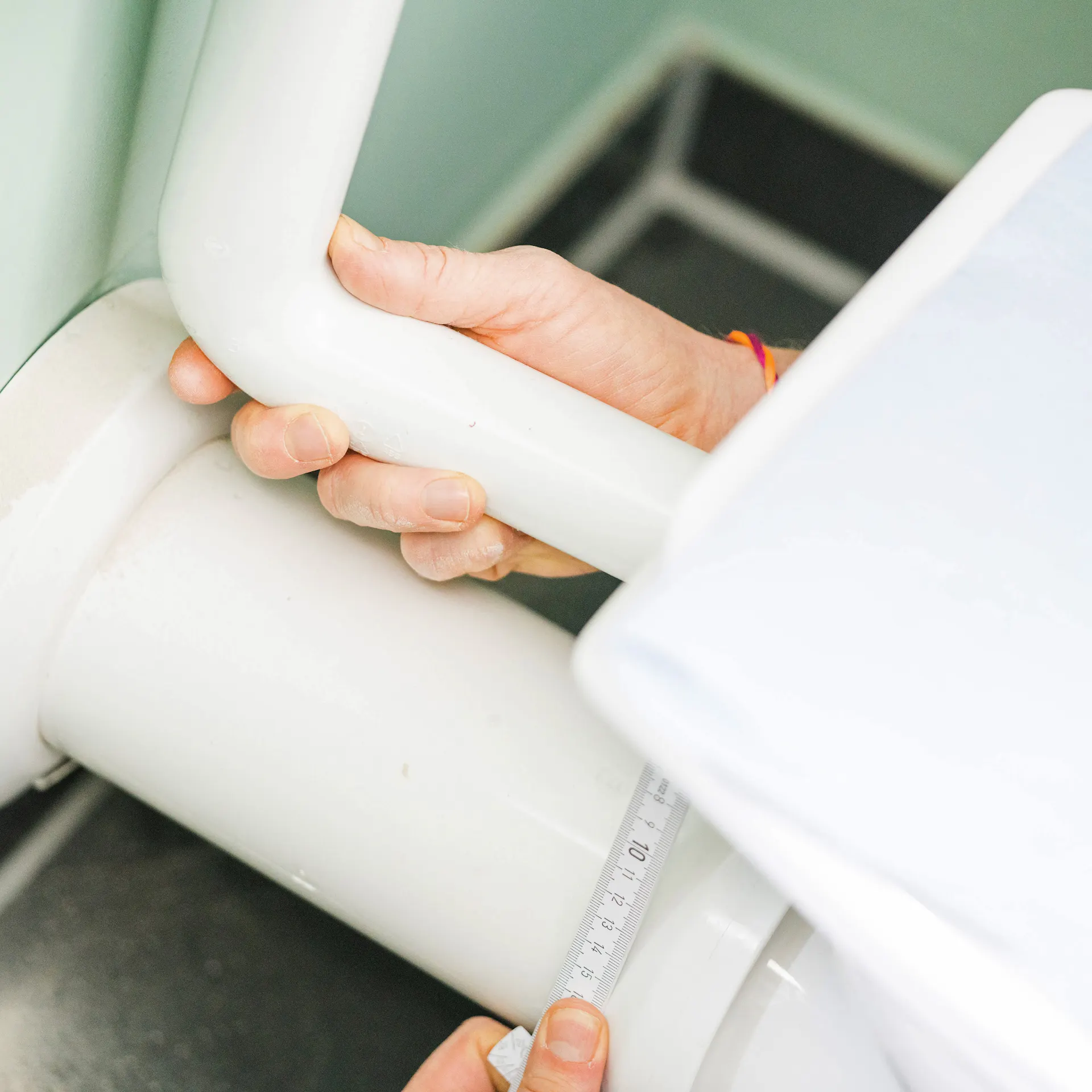 Handwerker bringt ein Spülrohr an.