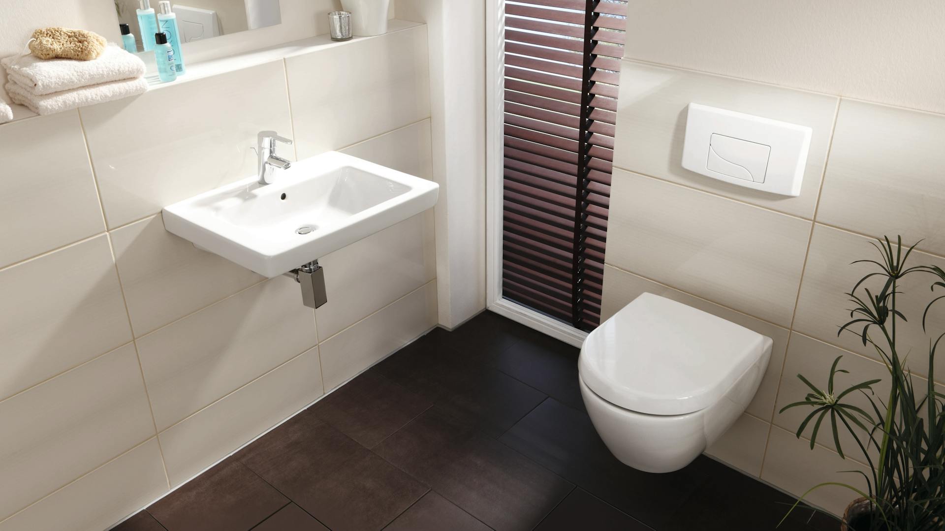 Modernes Badezimmer mit Toilette und weißem Toilettendeckel.