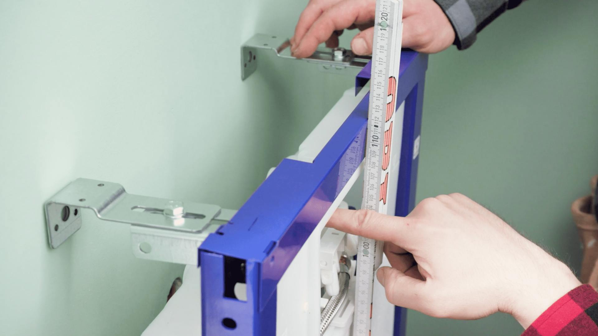 Person installiert Vorwandelement für das WC im Badezimmer.