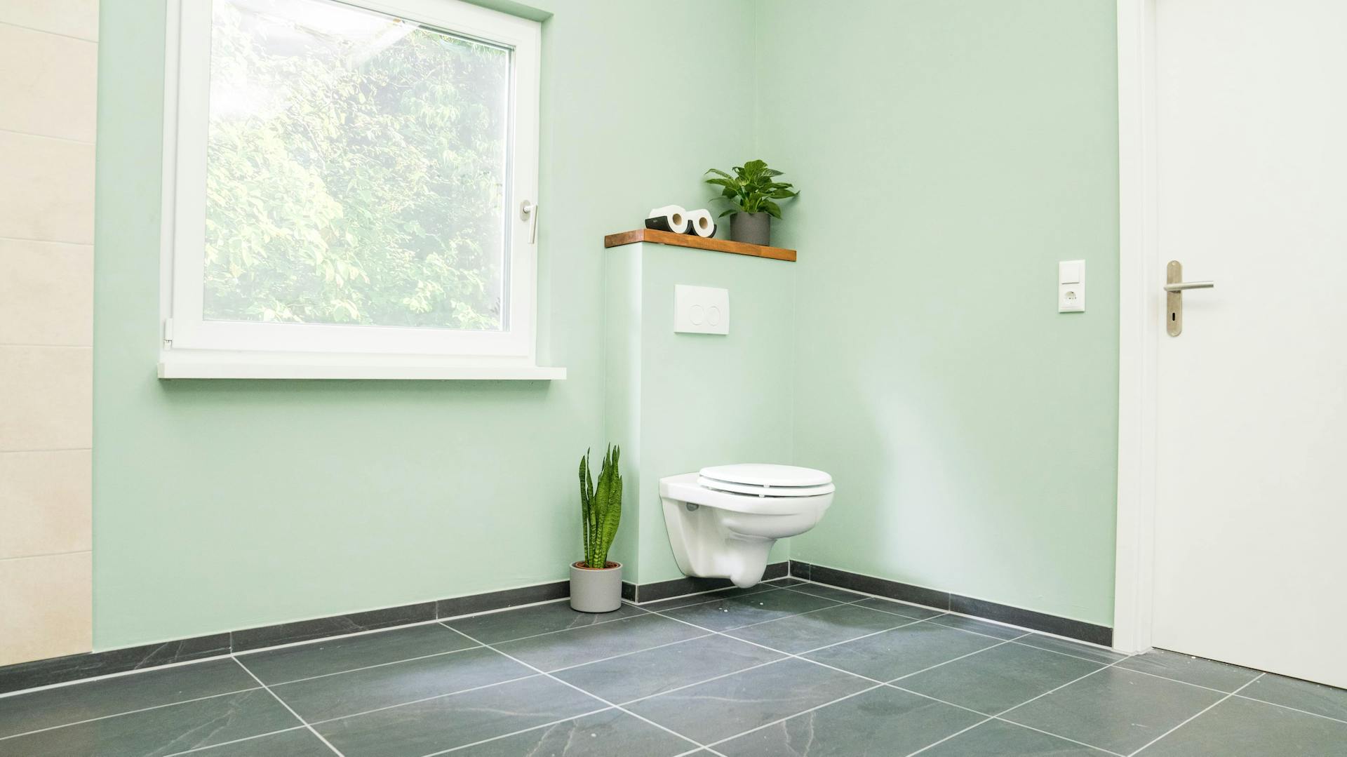 Mintgrünes Badezimmer mit Trockenbauelement für das WC