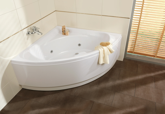 Eckbadewanne vor weißer Badezimmerwand mit Armatur und Handtuch.