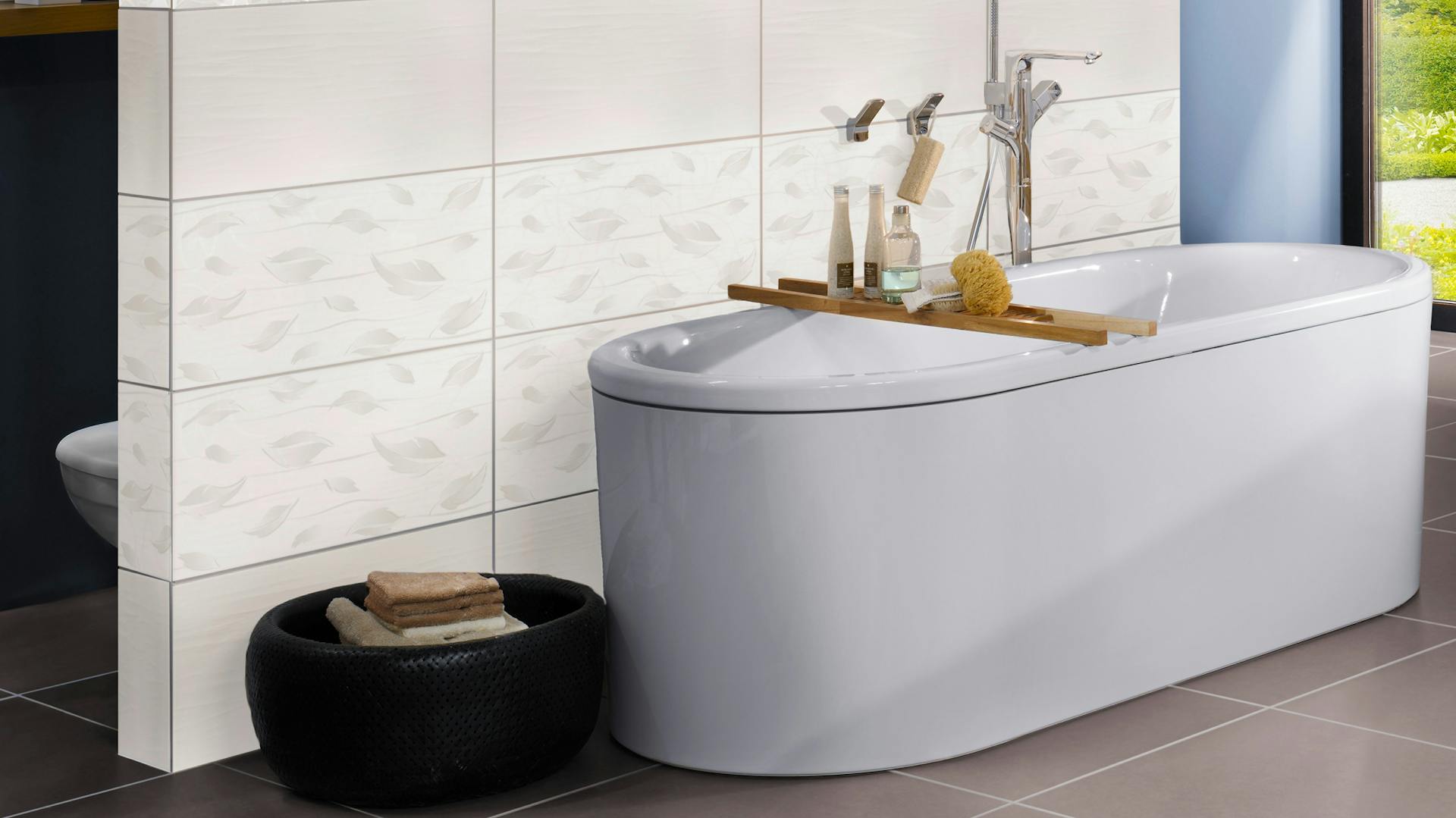 Eine freistehende Badewanne an einer Mauer oder Wand in einem modernen Badezimmer.