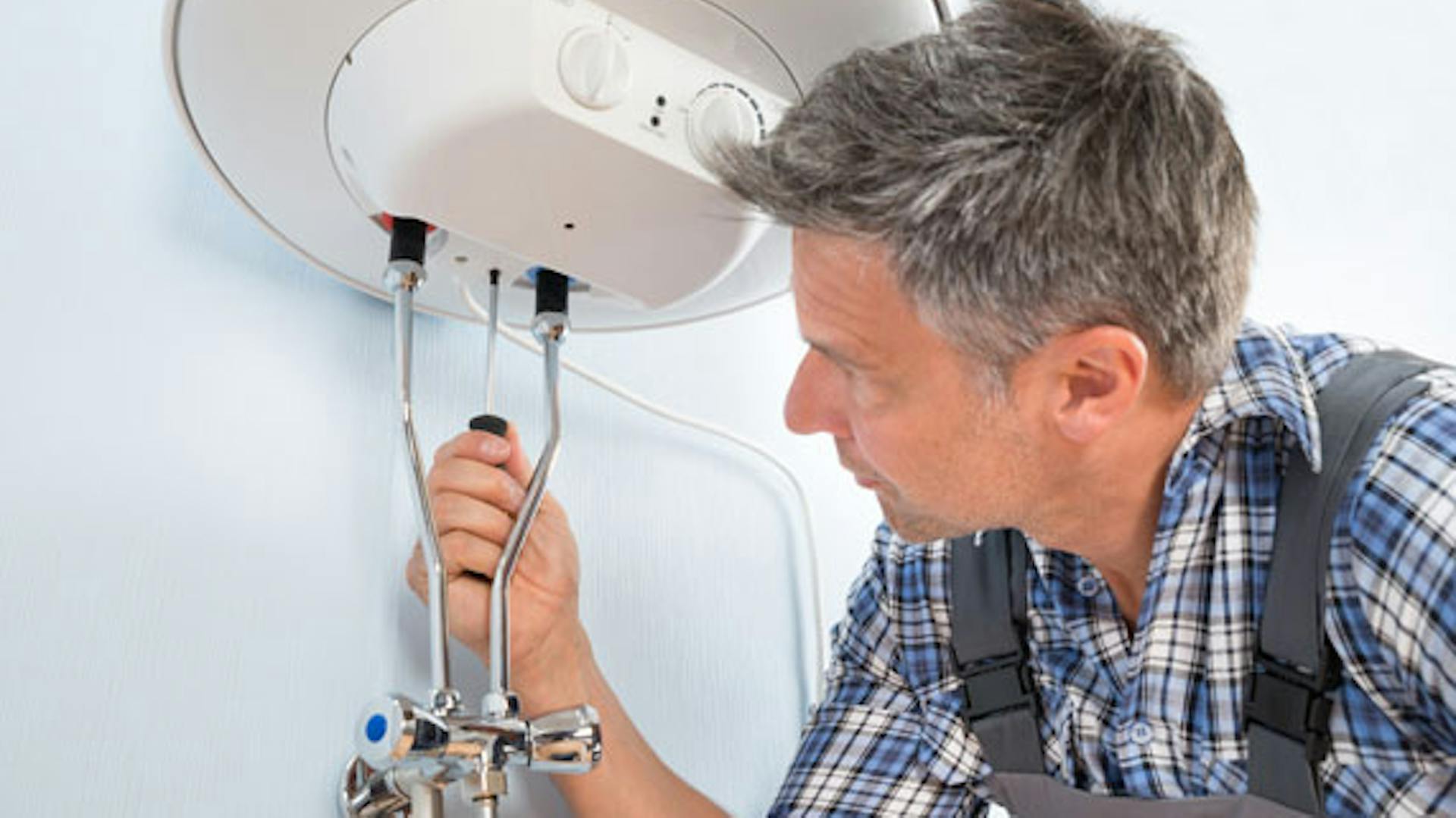 Egy barkácsoló vízkőteleníti a bojlert.