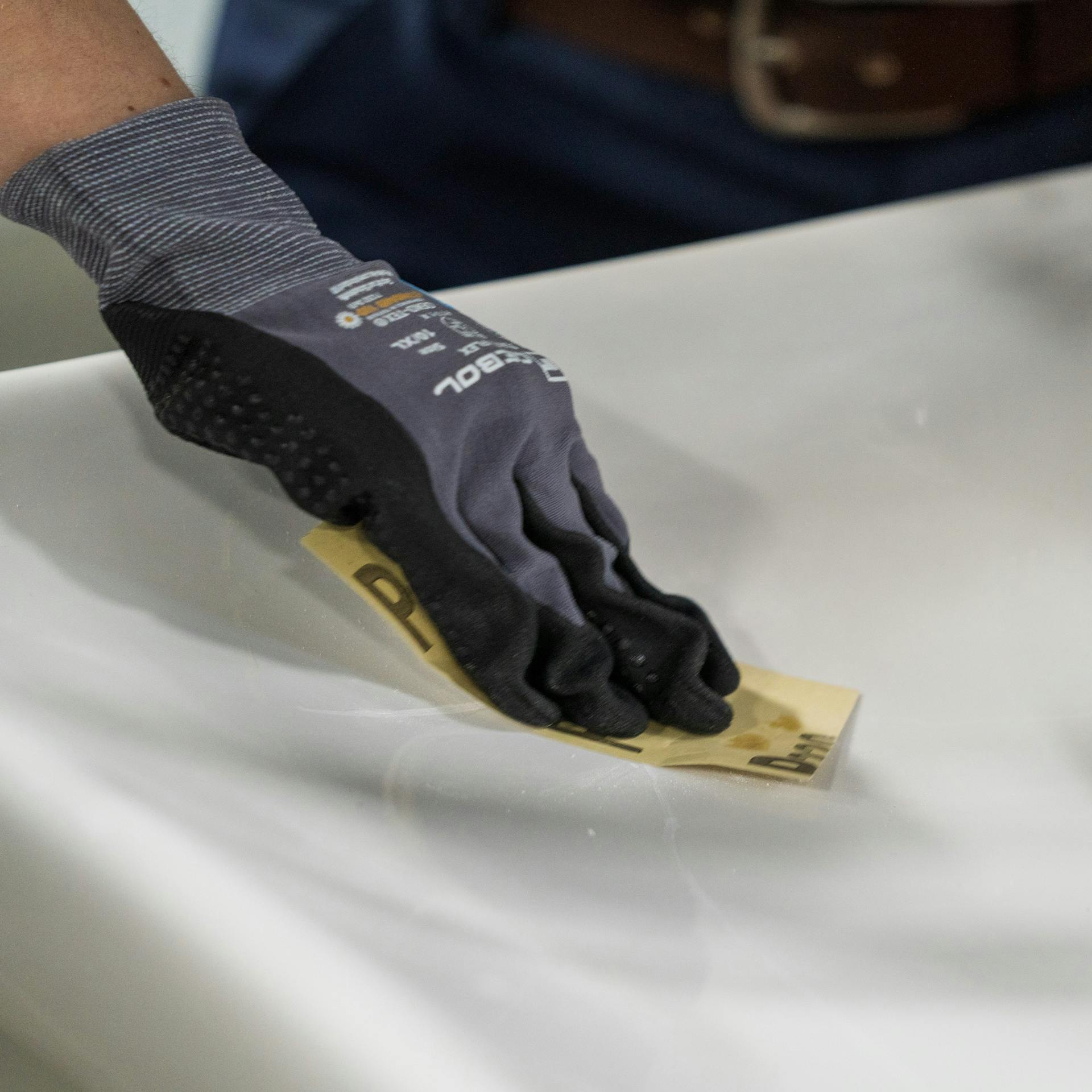 Heimwerkerin schleift Spachtelmasse im Waschbecken ab.