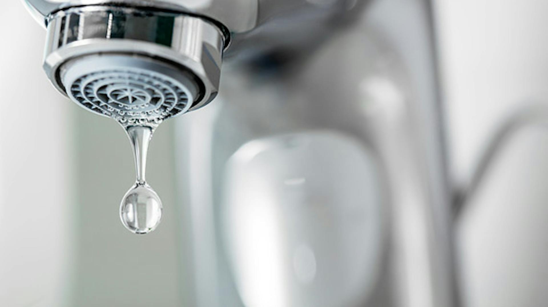 Ein Tropfen löst sich aus dem Wasserhahn.