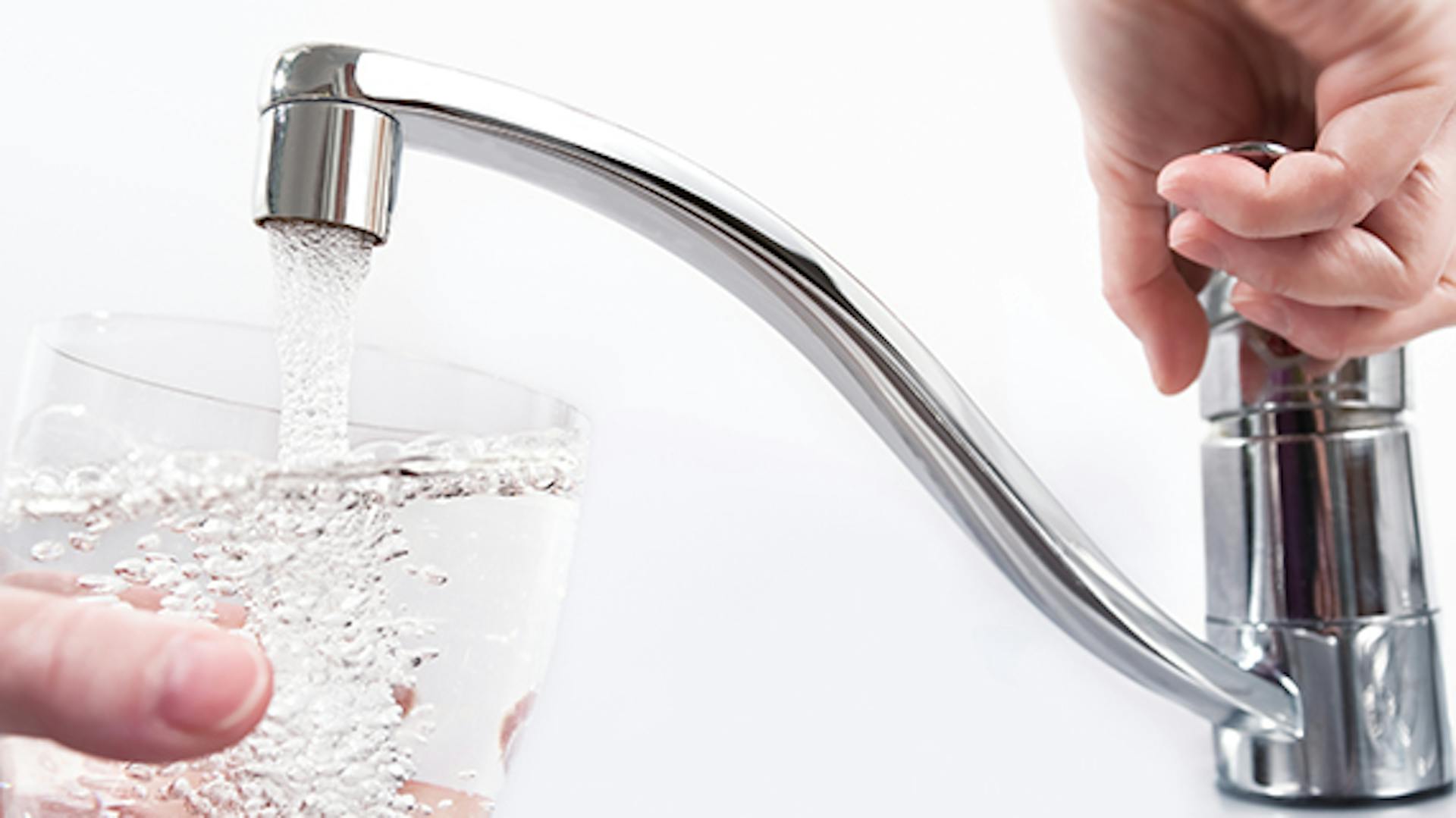 Egy csapból ivóvíz folyik egy pohárba.