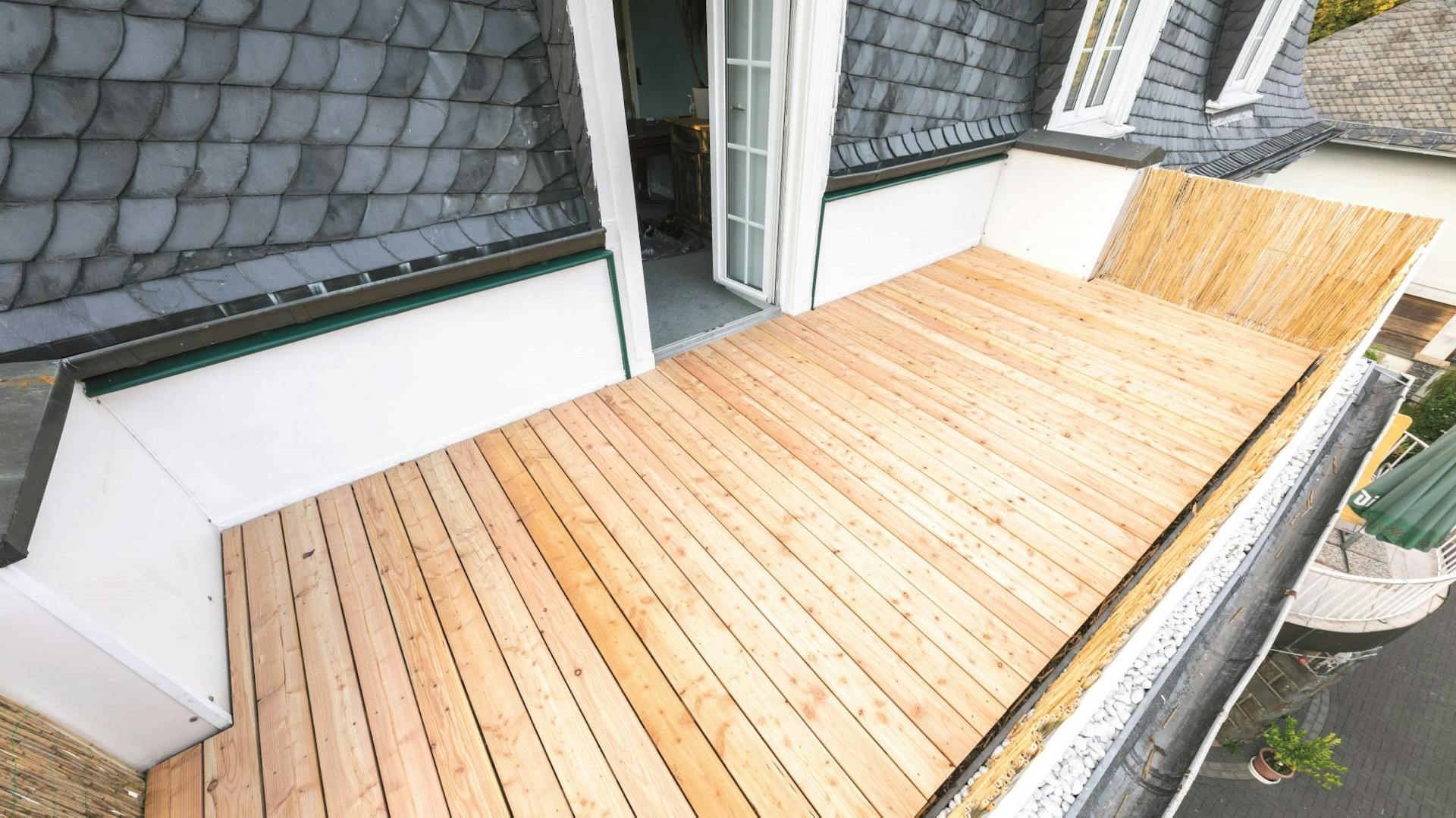 Balkon mit Holzboden und geöffneter Eingangstür aus einer Ansicht von oben