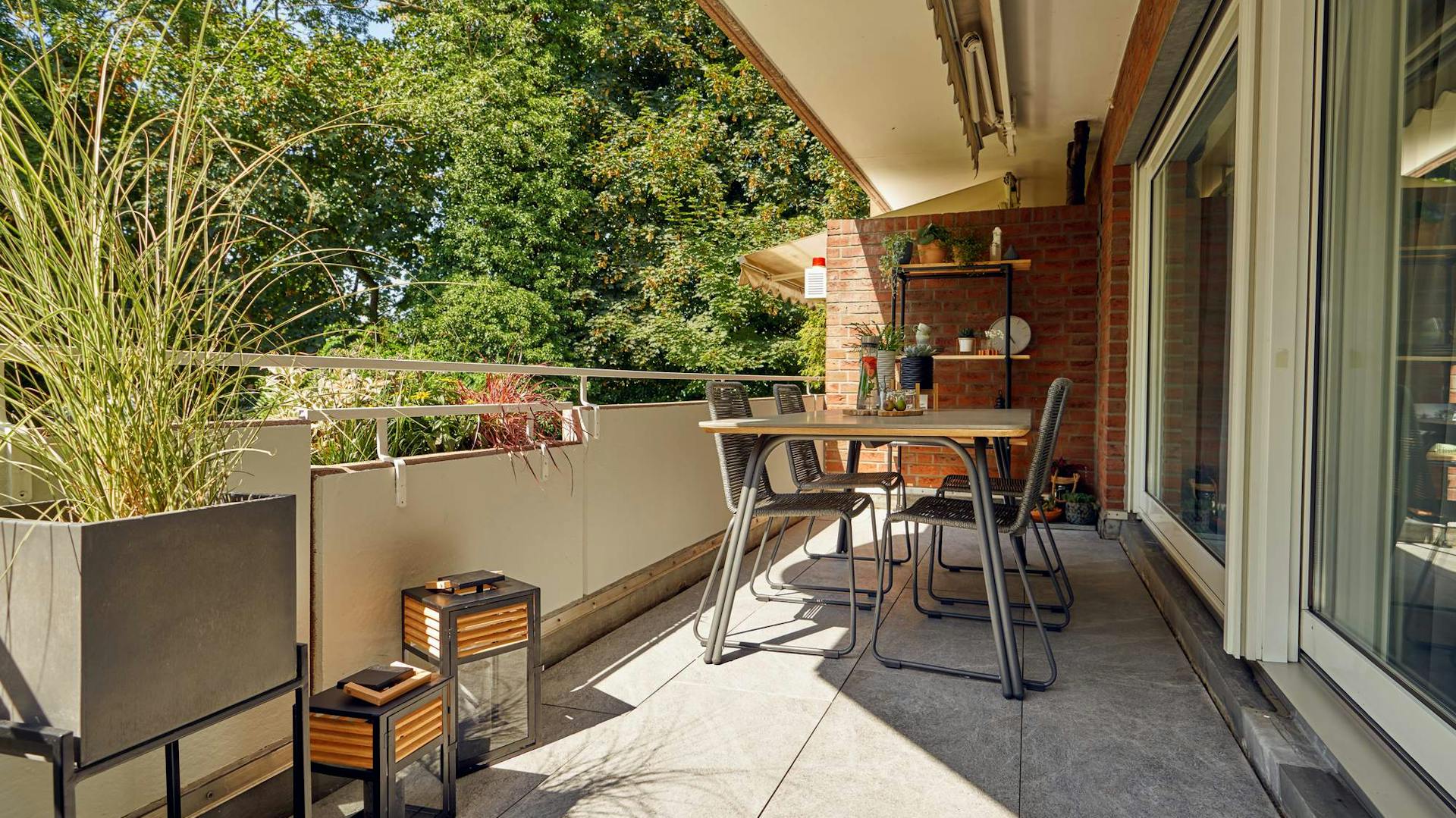 Balkon mit Holzfliesen und Loungemöbeln