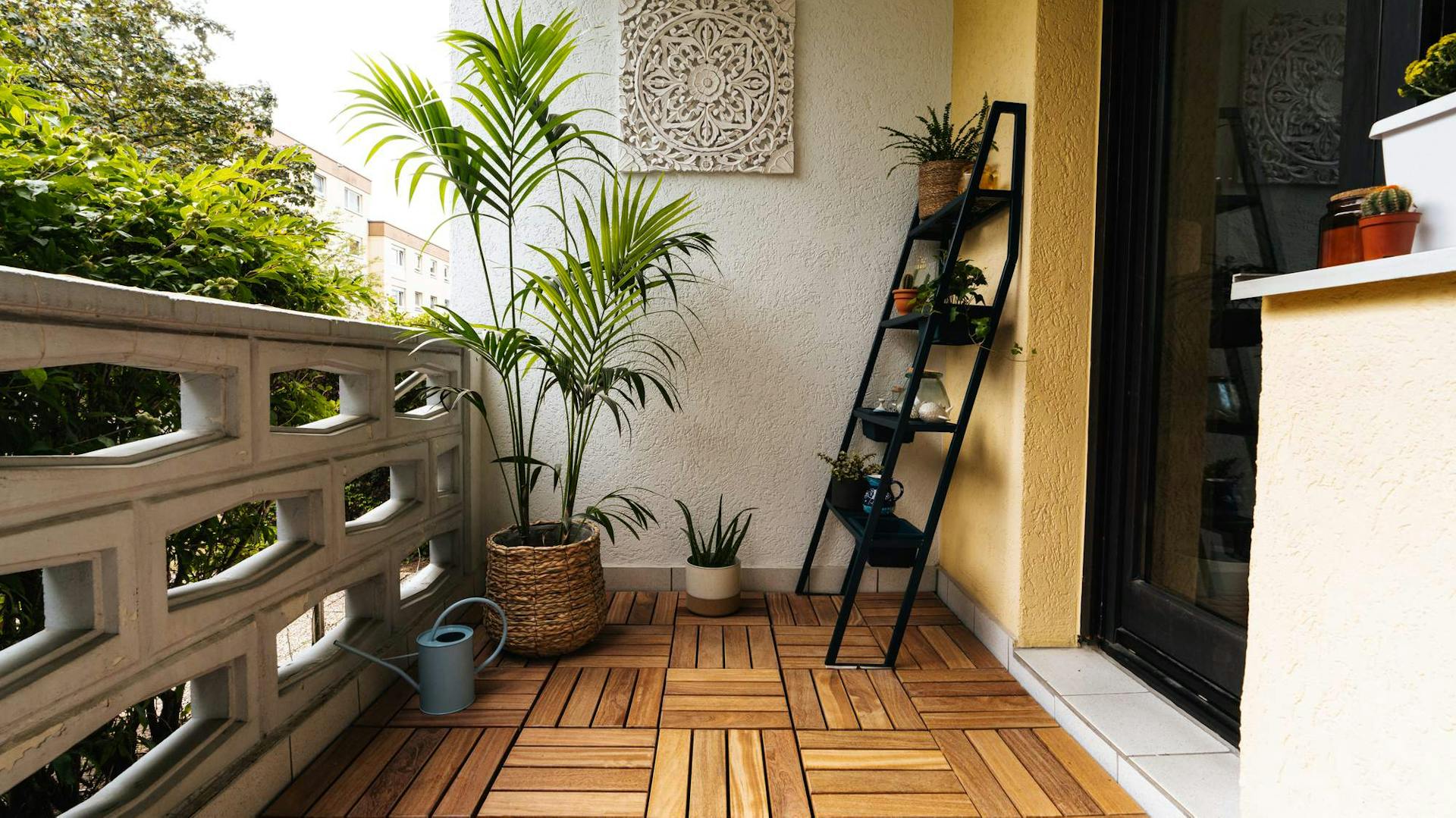 Balkon mit Holzfliesen, Blumenregal und Pflanzen