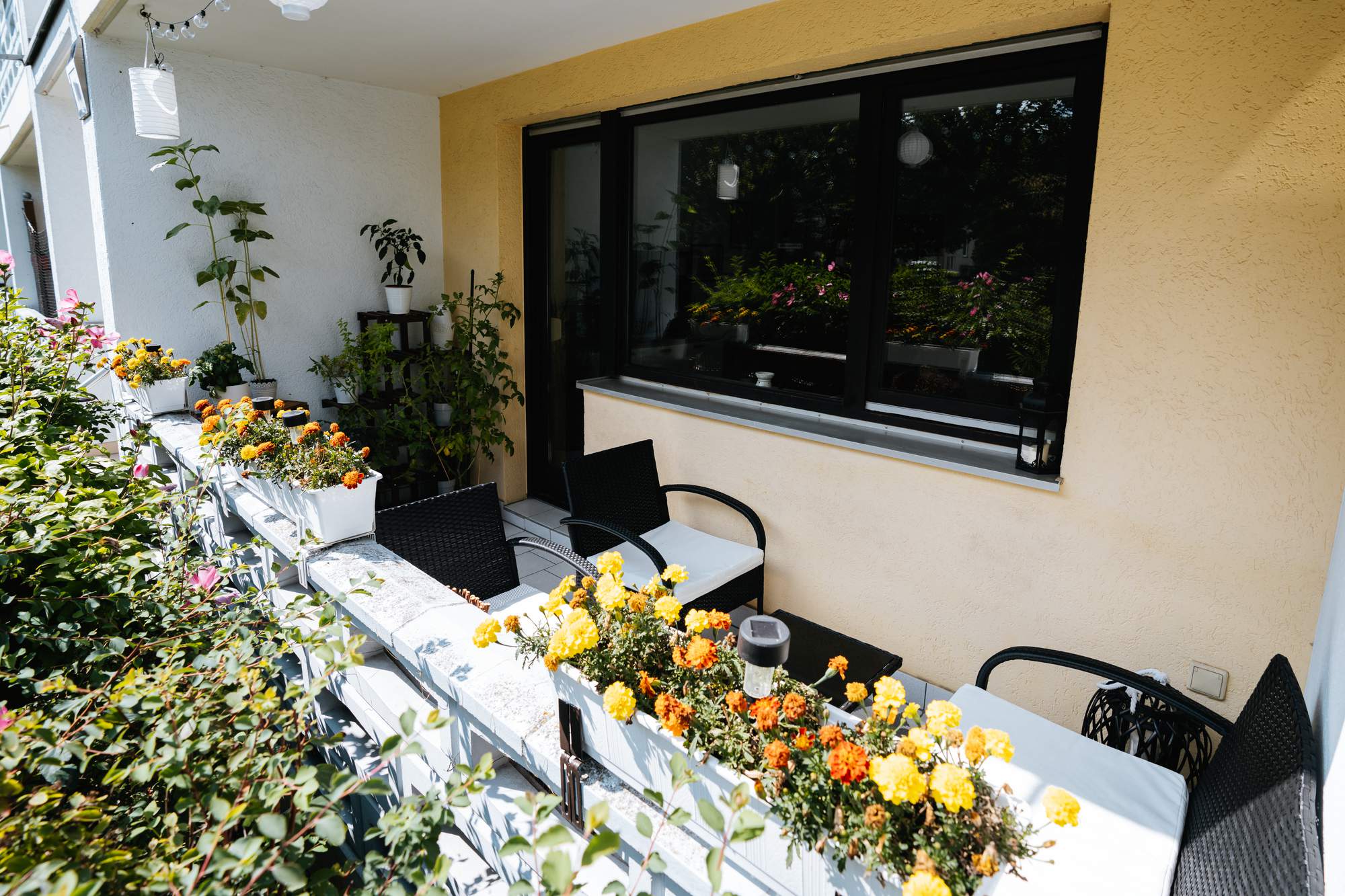 Balkon mit Sitzmöbeln und Blumenkästen