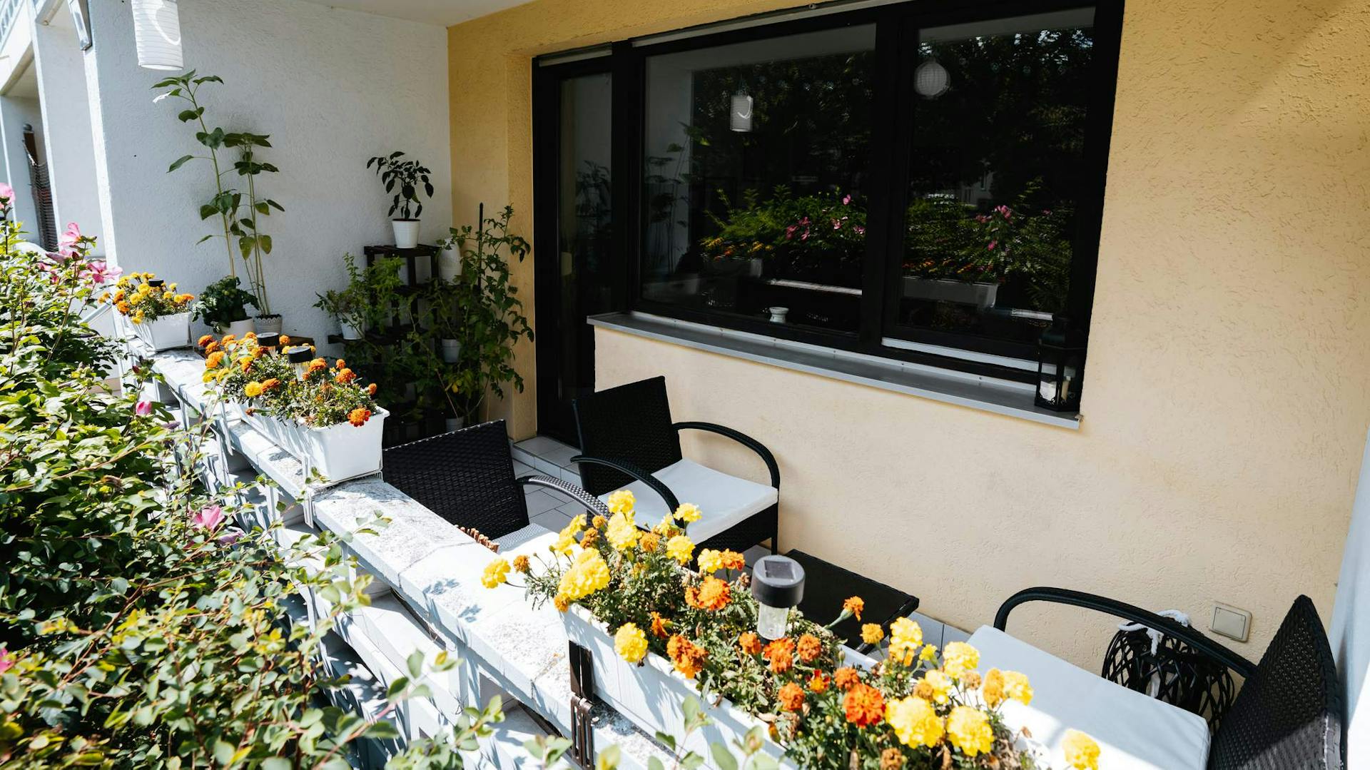 Balkon mit Sitzmöbeln und Blumenkästen