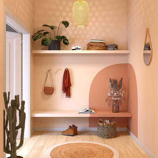 Ein Flur in warmem Beige und einer orangen Farbfläche in der Ecke, nutzt eine an der Wand angebrachten Holzplatte als Stauraum.