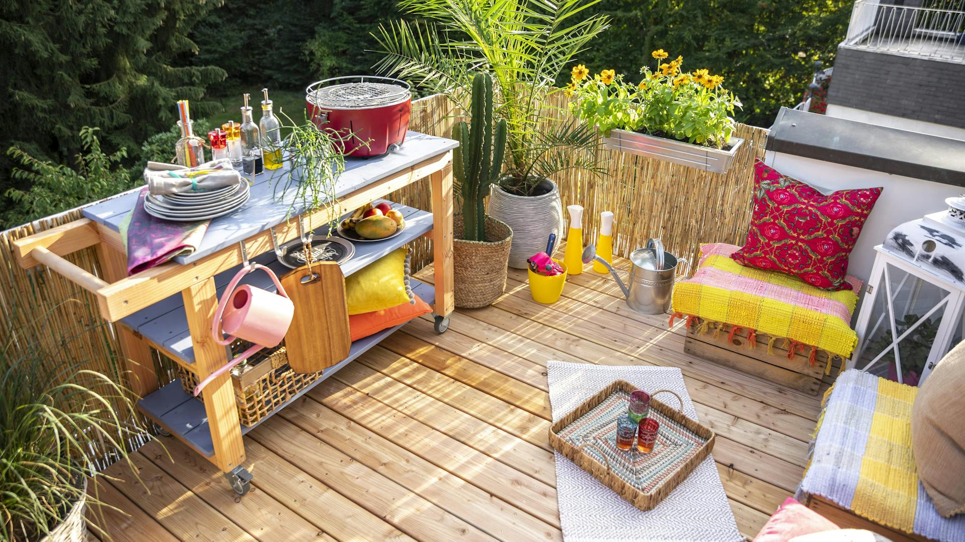 Kleiner Balkon mit mehreren Sitzgelegenheiten bunt dekoriert