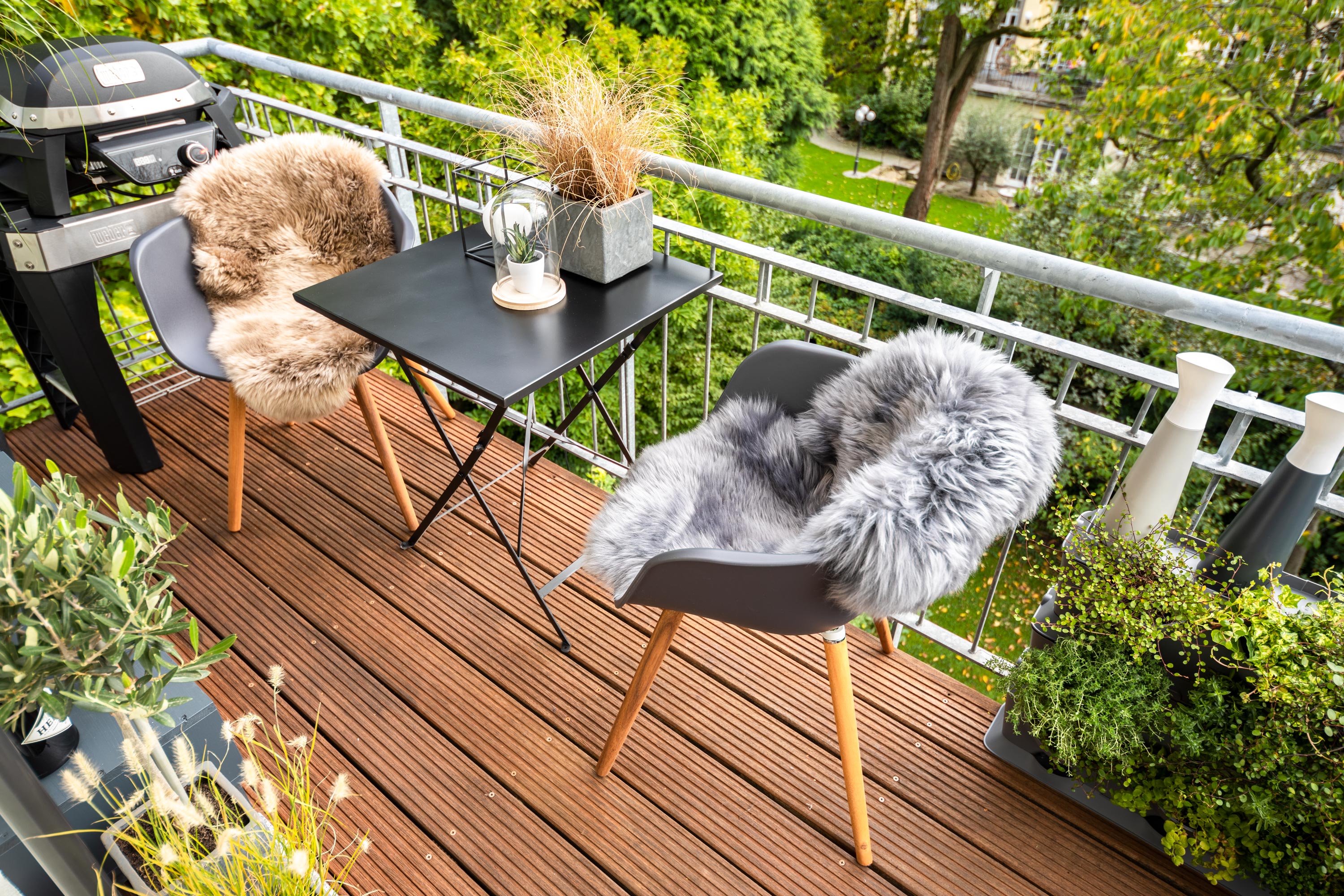 Balkon mit einer Sitzgruppe mit einem kleinen Esstisch und einem Grill