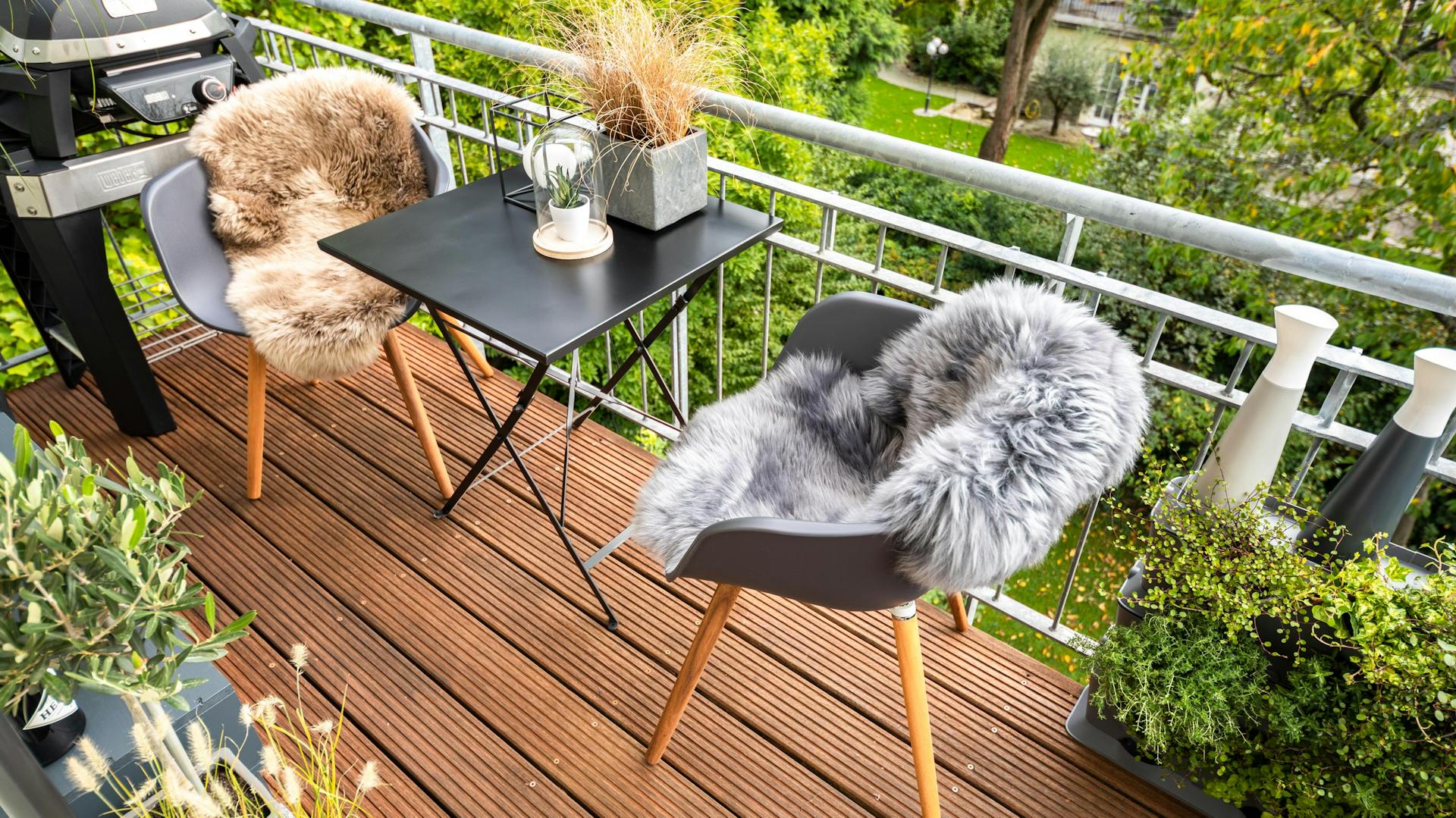 Balkon mit einer Sitzgruppe mit einem kleinen Esstisch und einem Grill