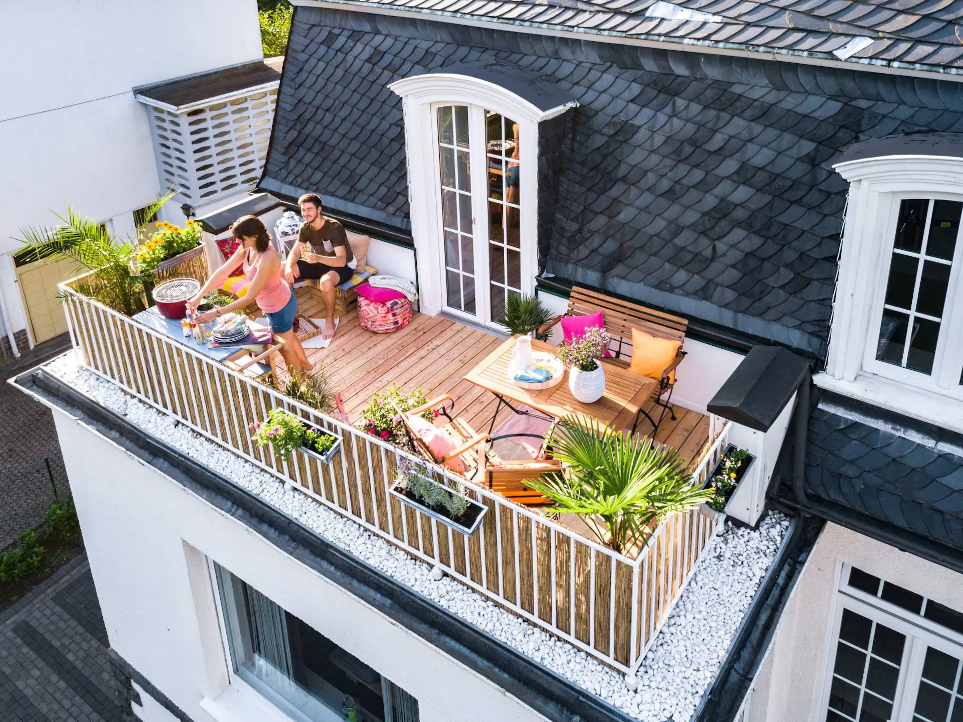 Coppia su un balcone con pavimento in legno visti dall'alto