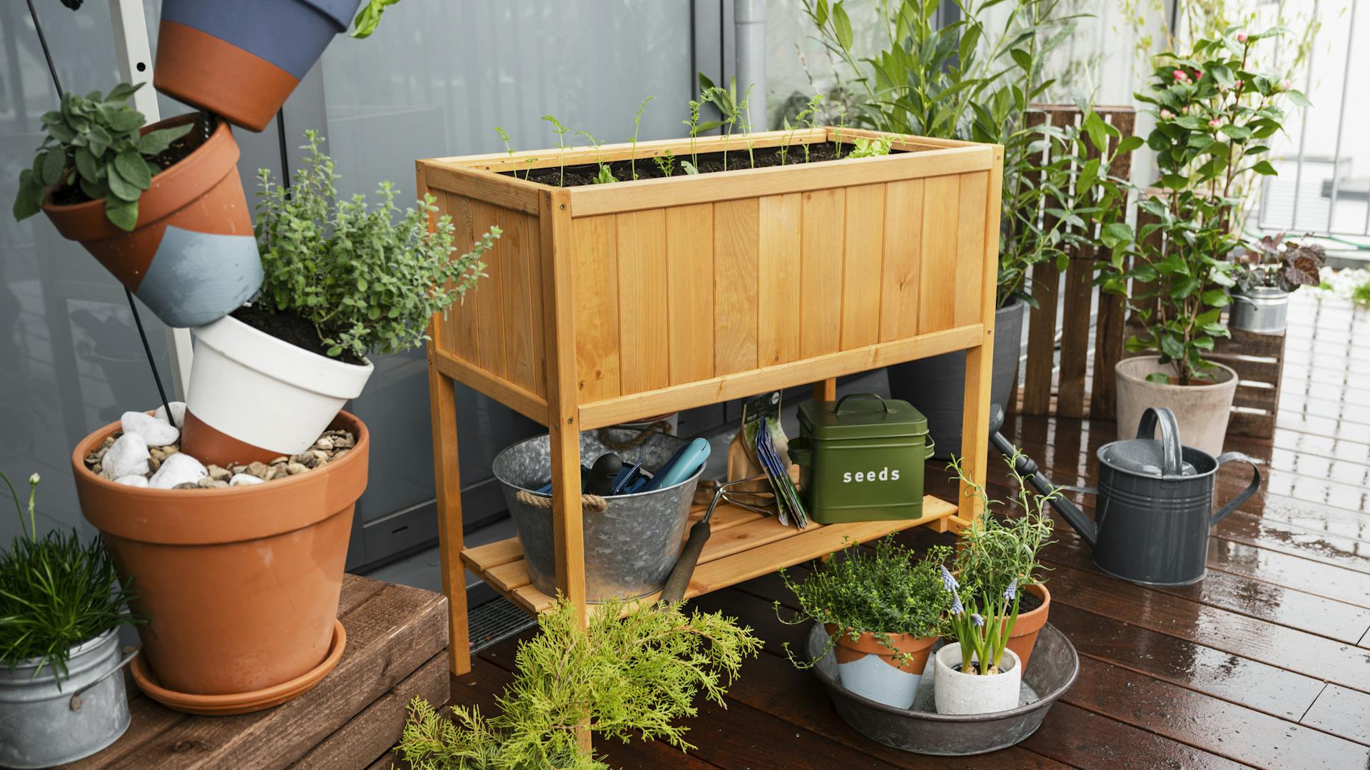 Hölzernes Hochbeet mit Stelzen auf einem Balkon