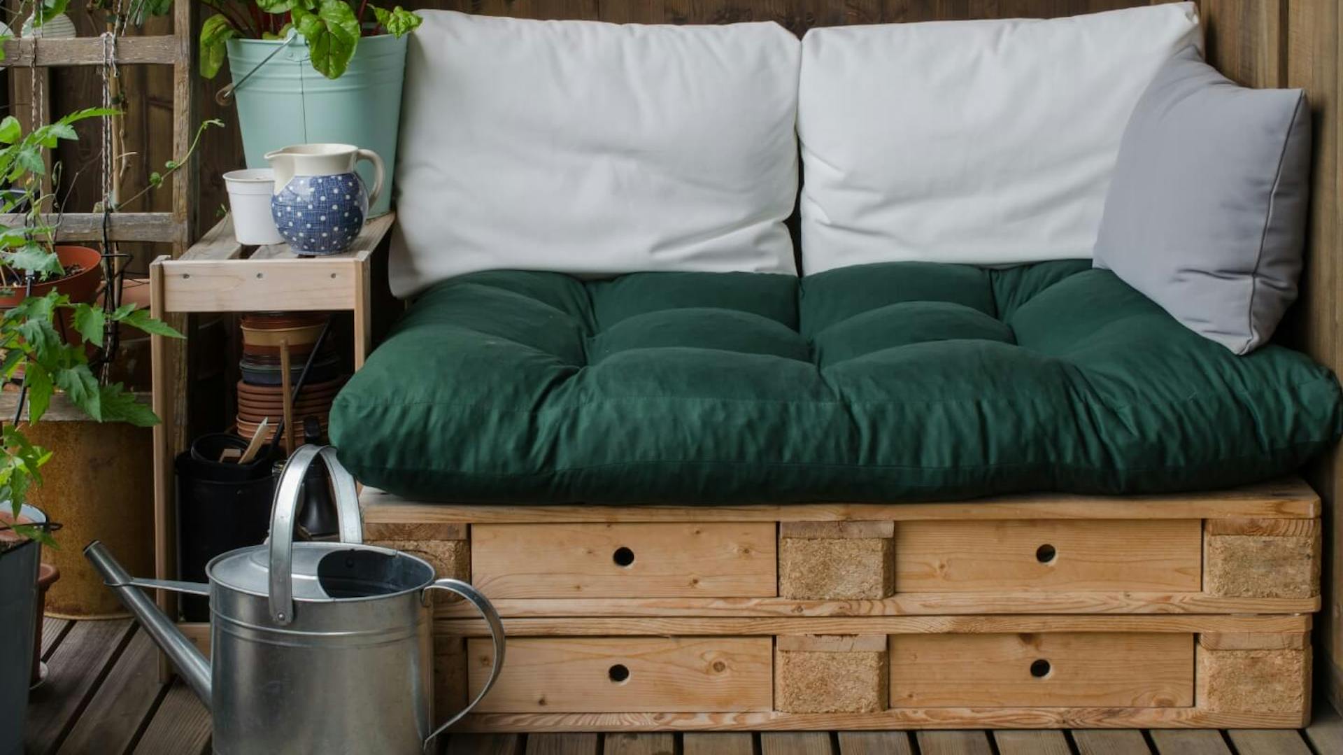 Raklapbútor színes párnákkal egy kis erkélyen