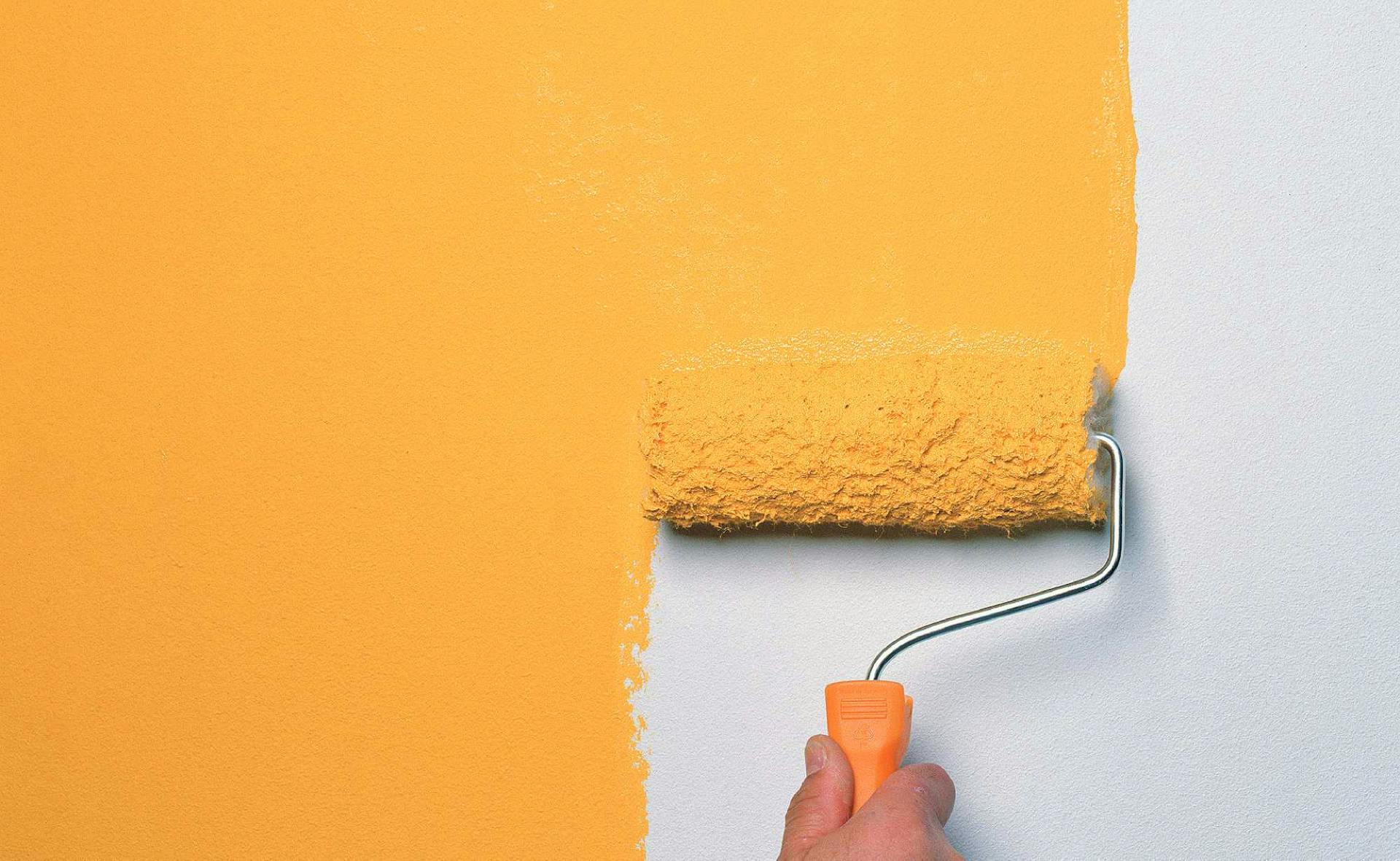 La parete interna viene verniciata con un colore arancione utilizzando un rullo per pittura.