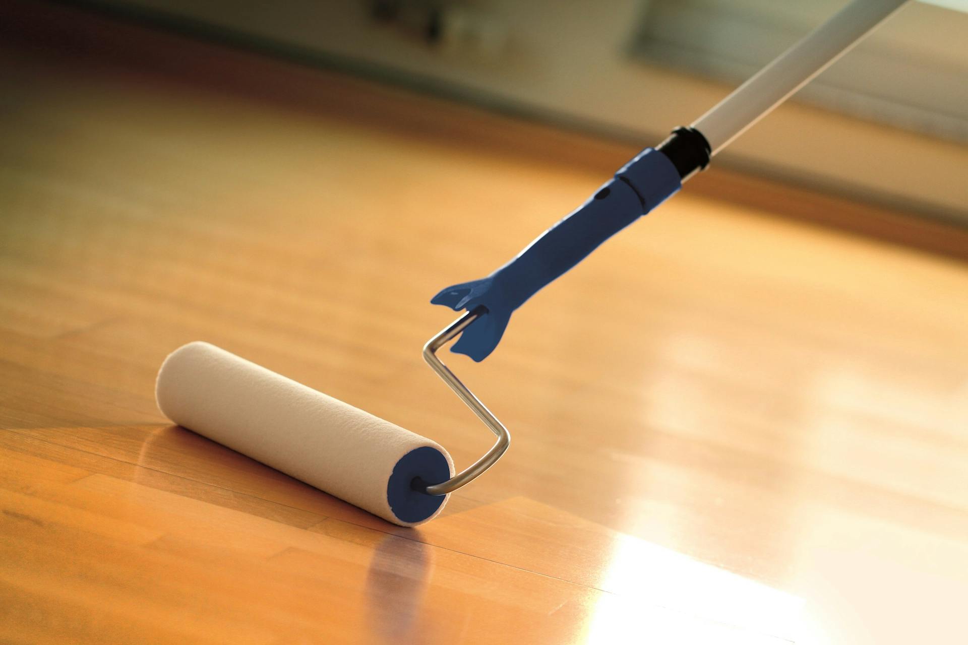 Un pavimento viene trattato con vernice per parquet.