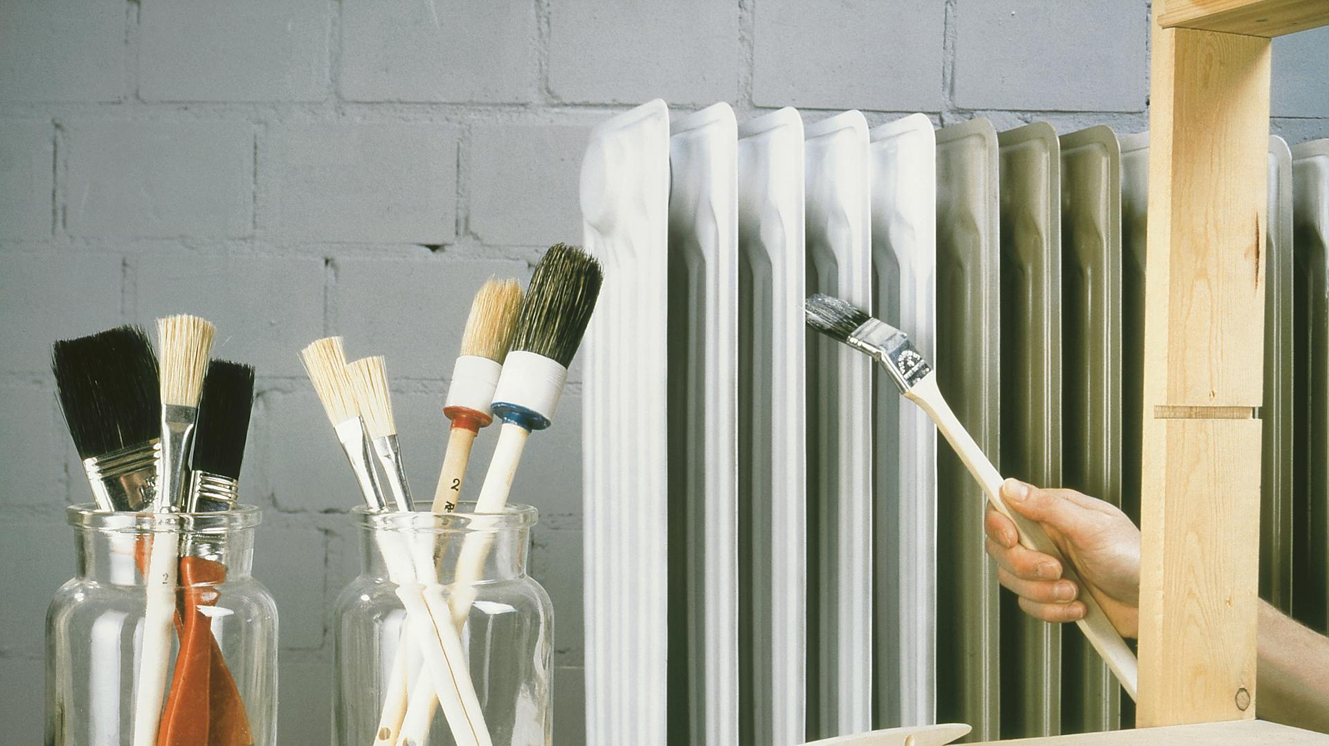 Richtige Farben für jeden Zweck, zum Beispiel für Heizkörper, wie hier mit Pinseln im Vordergrung abgebildet.