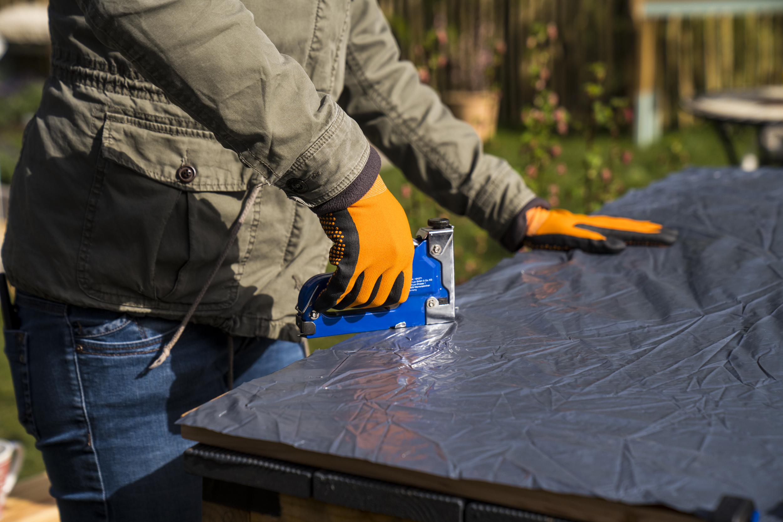 Kutil přišije na vnitřní stranu podlahových prken fólii, aby utěsnil bramborovou věž.