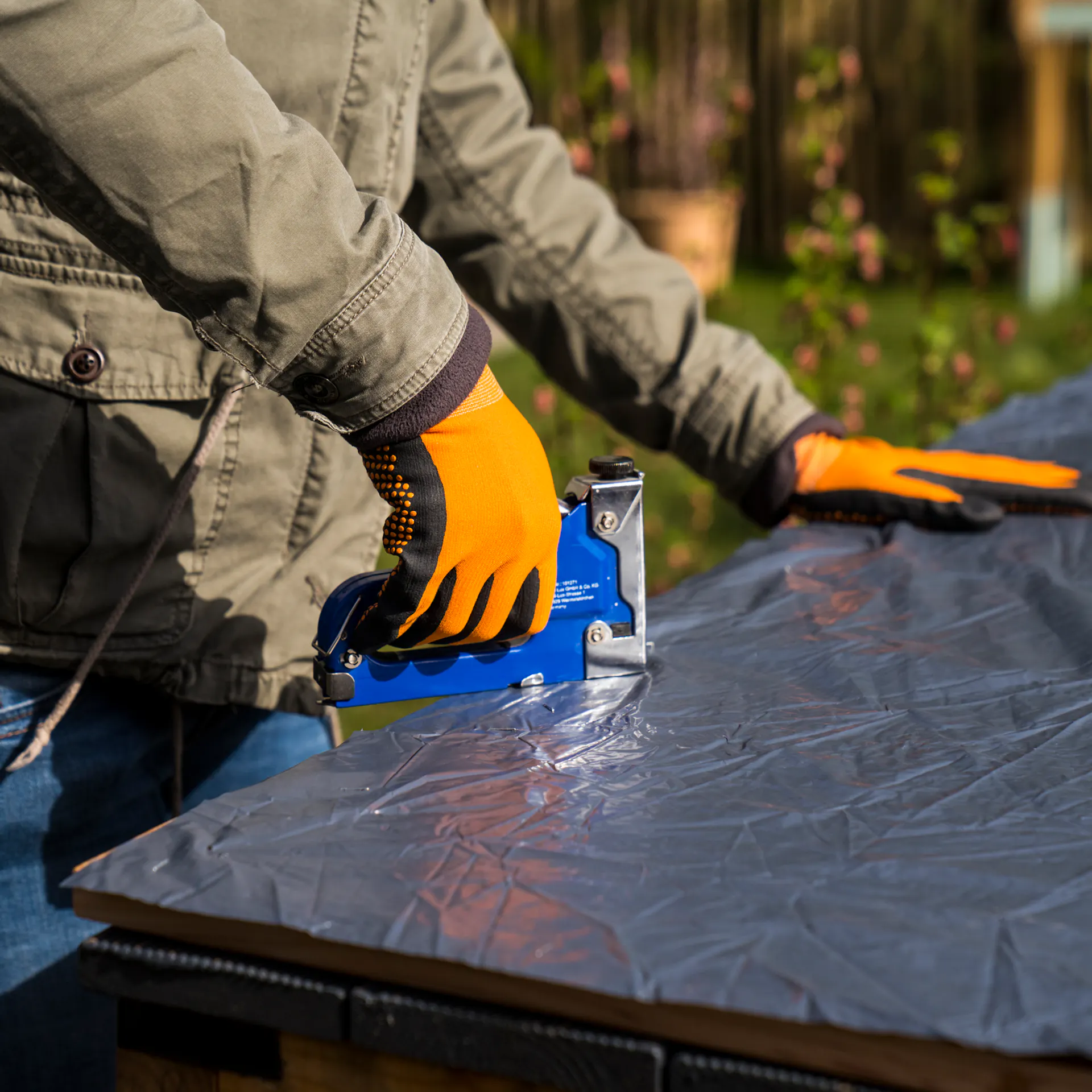 Kutil přišije na vnitřní stranu podlahových prken fólii, aby utěsnil bramborovou věž.