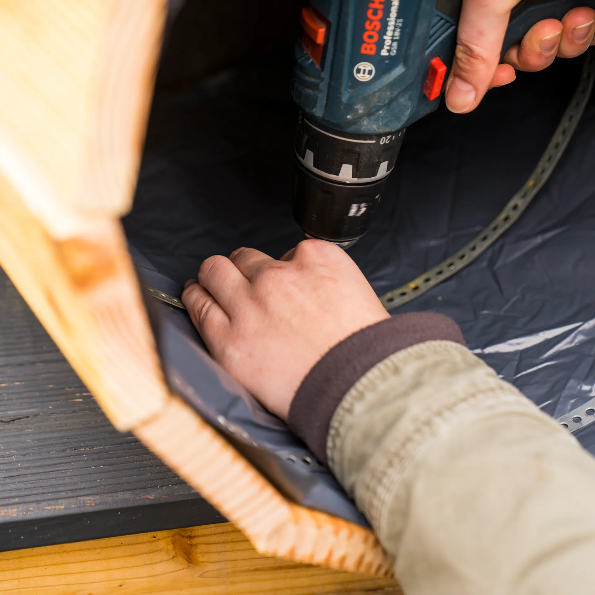 Kutil připevní děrovanou pásku ke stabilizaci bramborové věže nad dveřmi.