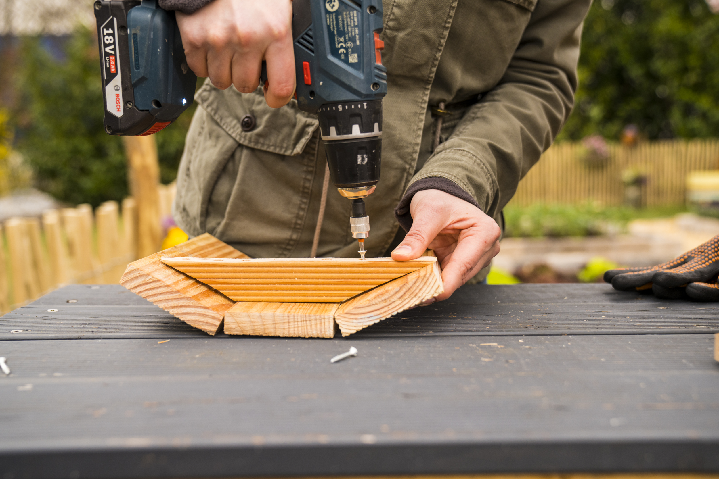 Kutil přišroubuje dvířka bramborové věže pomocí konektoru.