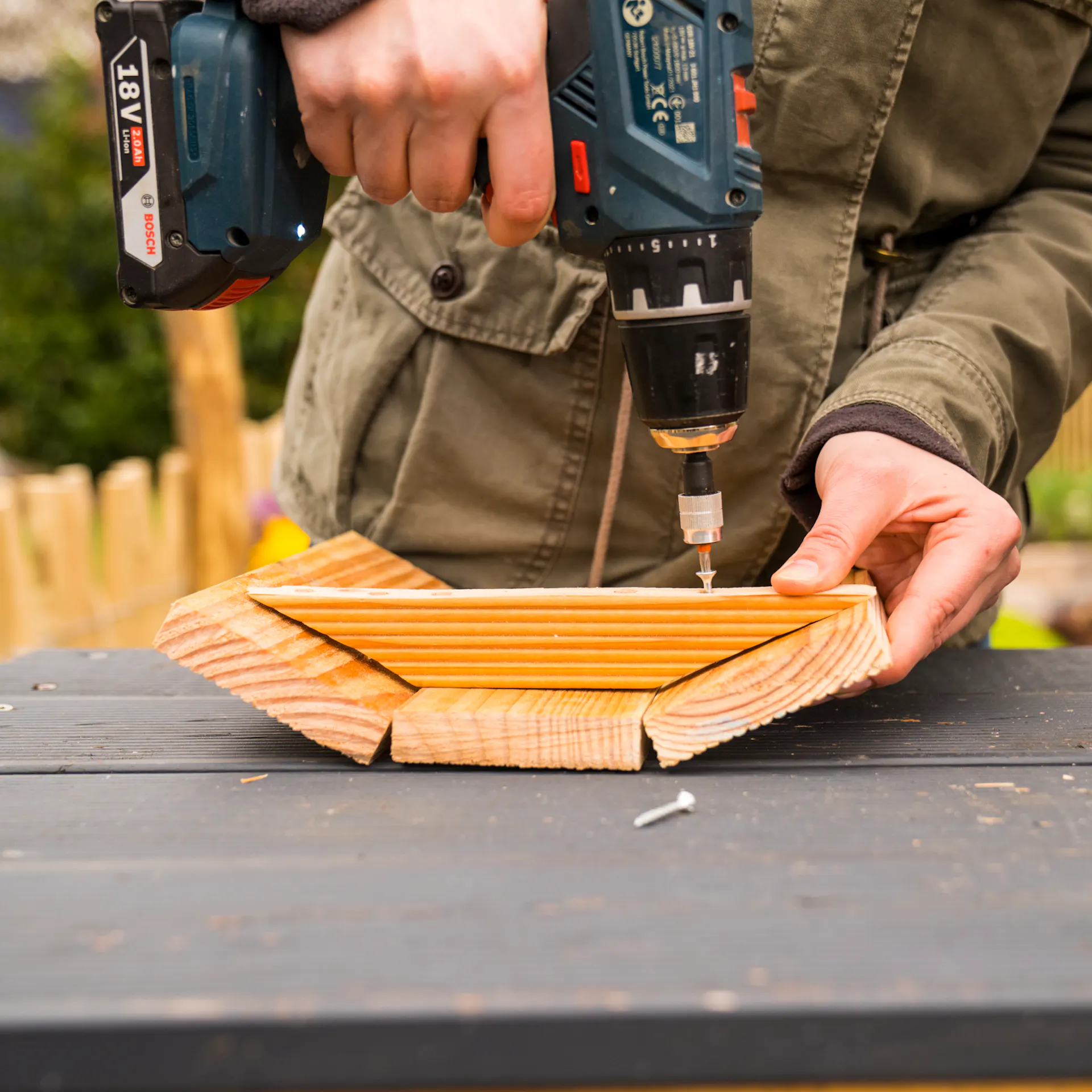 Kutil přišroubuje dvířka bramborové věže pomocí konektoru.