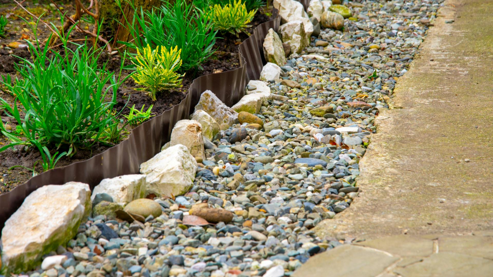 Ágyás műanyagból és nagy kövekből készült szegéllyel.