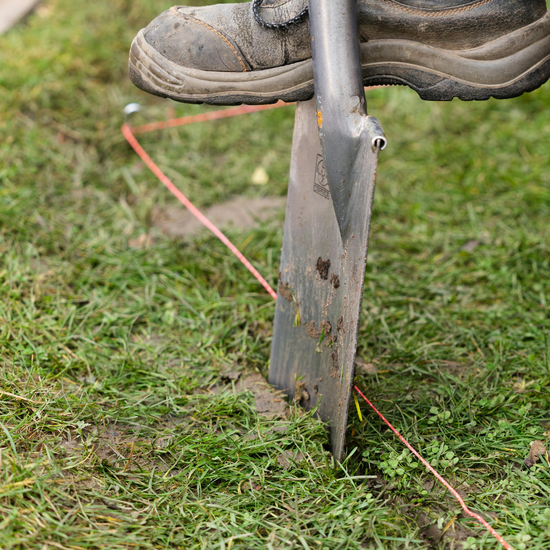 Person sticht mit Spaten die markierten Umrisse des Frühbeets aus.
