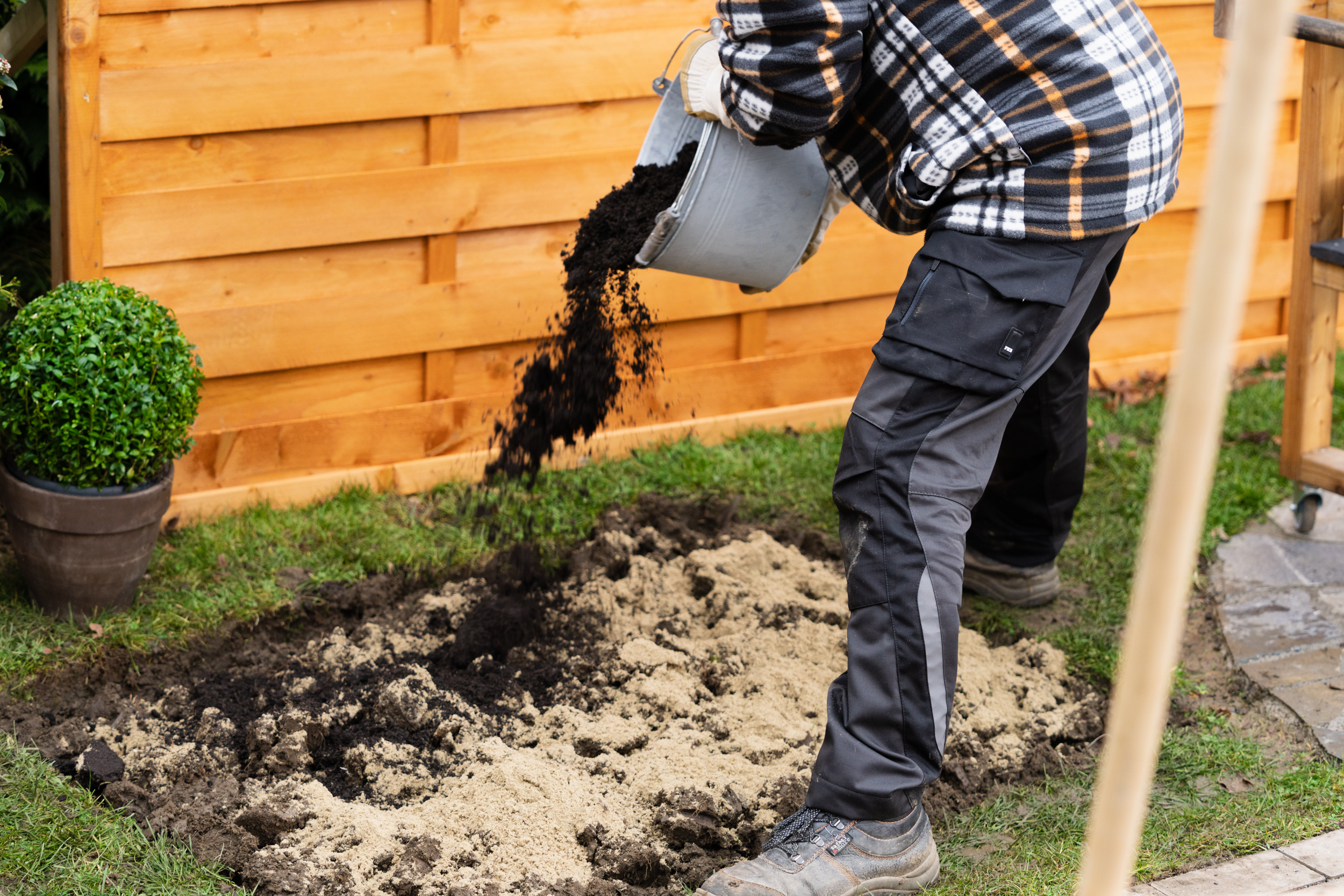 Homokot és komposztot kevernek a melegágy talajába.