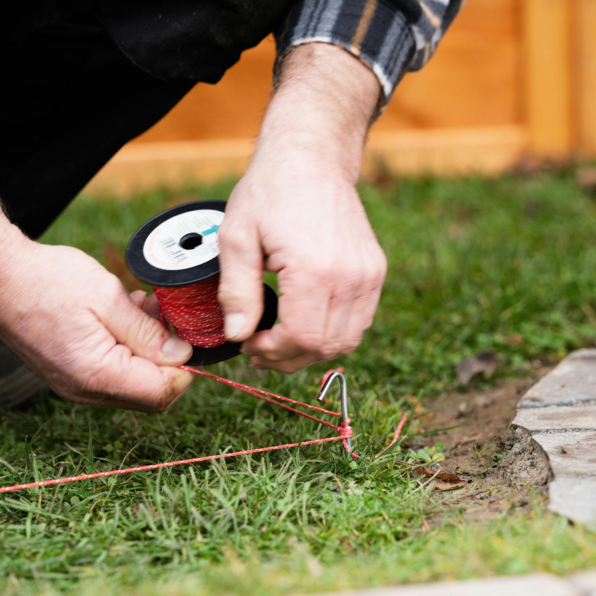 Person spannt Richtschnur zur Markierung des Standortes für das Frühbeet.