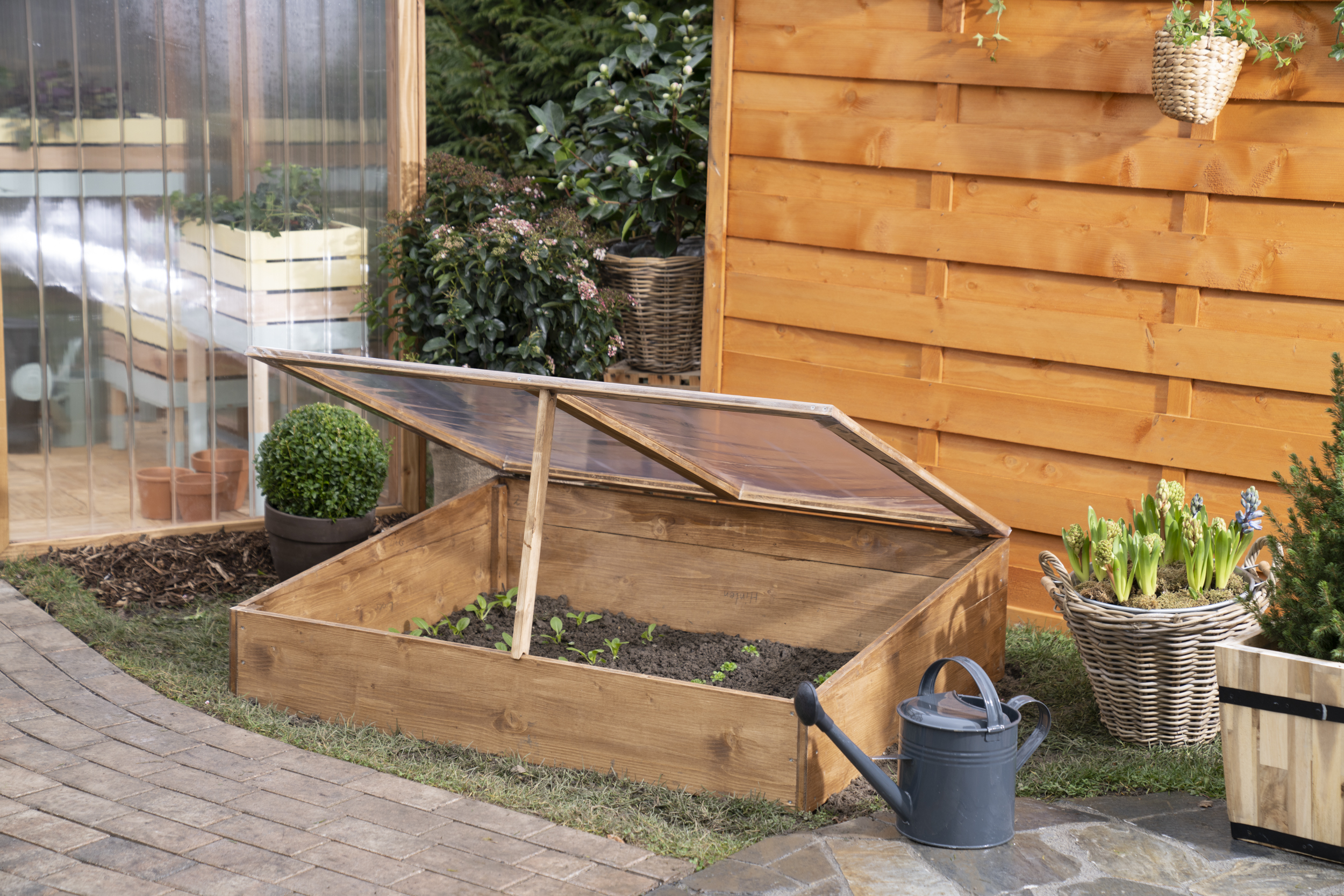 Semenzaio aperto e con piante accanto a una serra