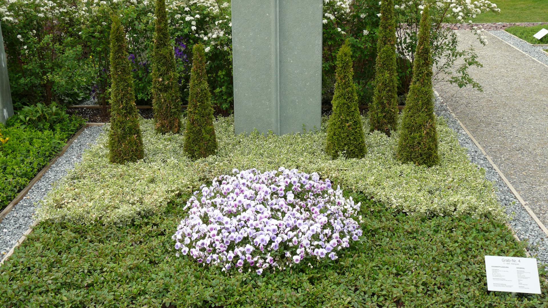 Grabbepflanzung vor einem Grabstein