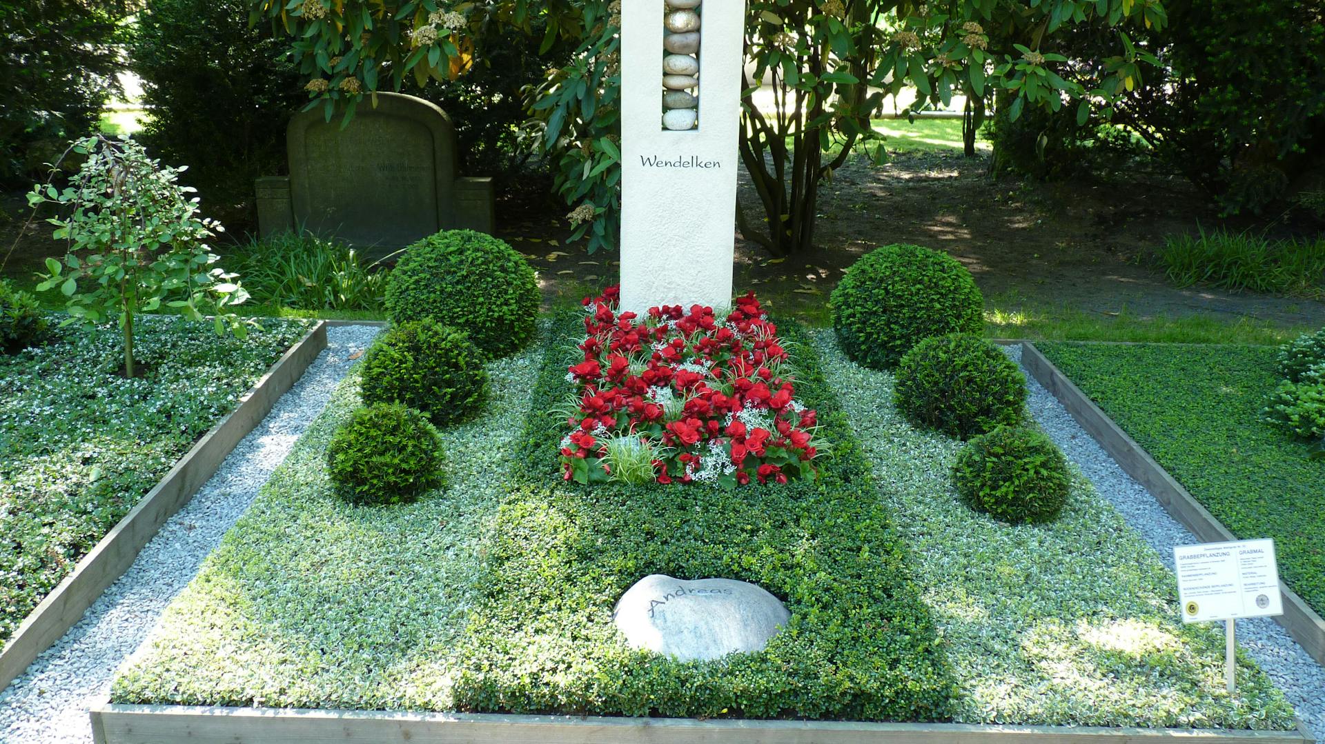 Großes Grab mit Grabbepflanzung, Grabstein und Trittstein