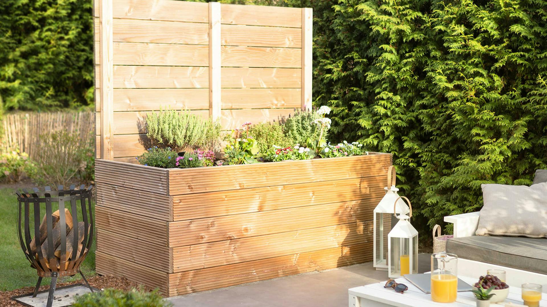 Seitenansicht des aus Vollholz selbstgebauten Hochbeet Alfred mit Sichtschutz.
