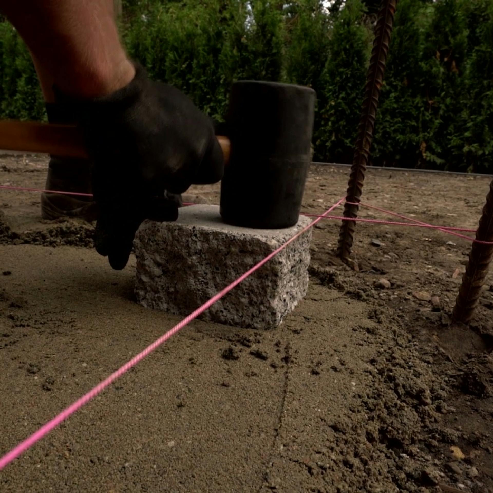 Ein Stein wird mithilfe eines Gummihammers gesetzt und gefestigt