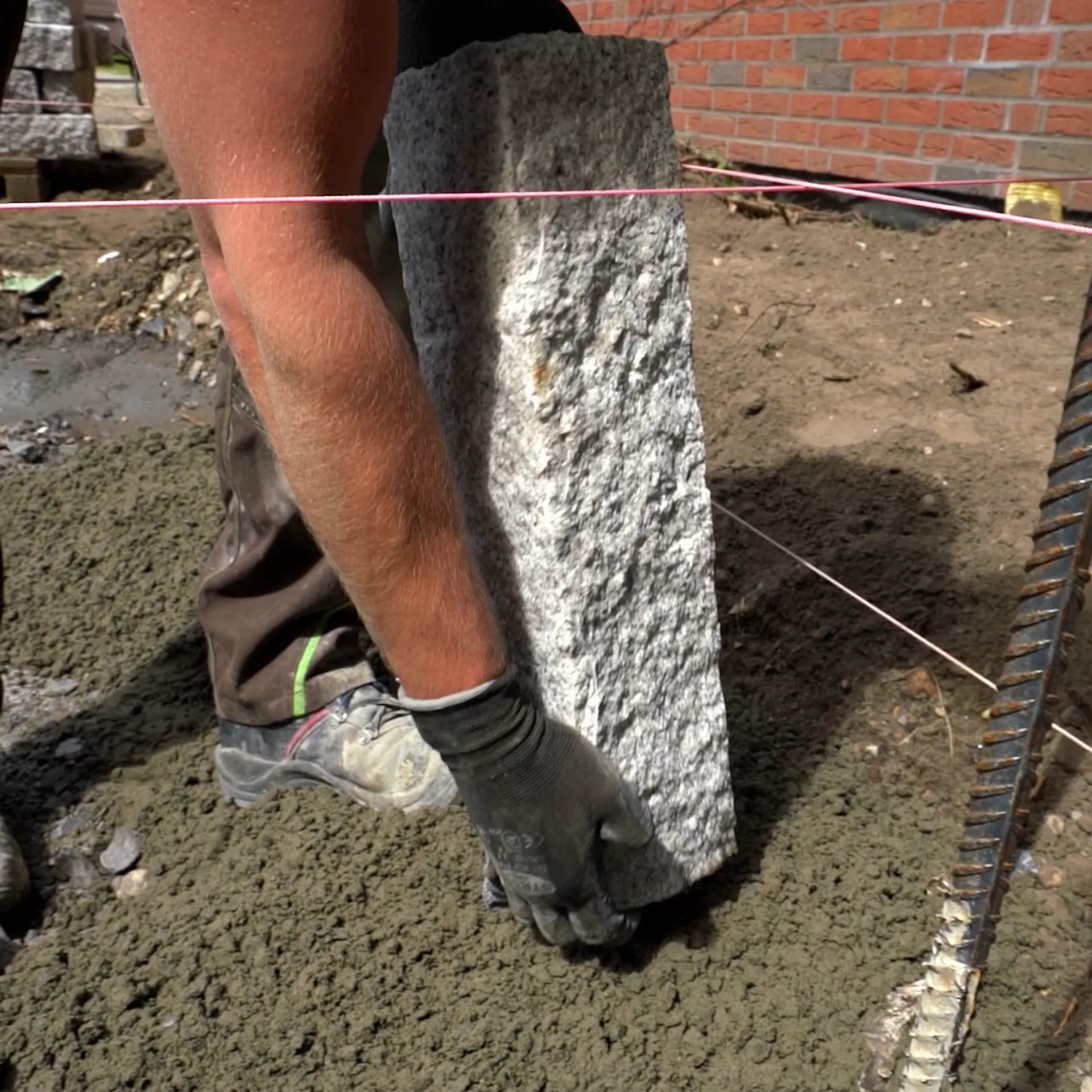 Jemand platziert eine Palisade in den Boden.