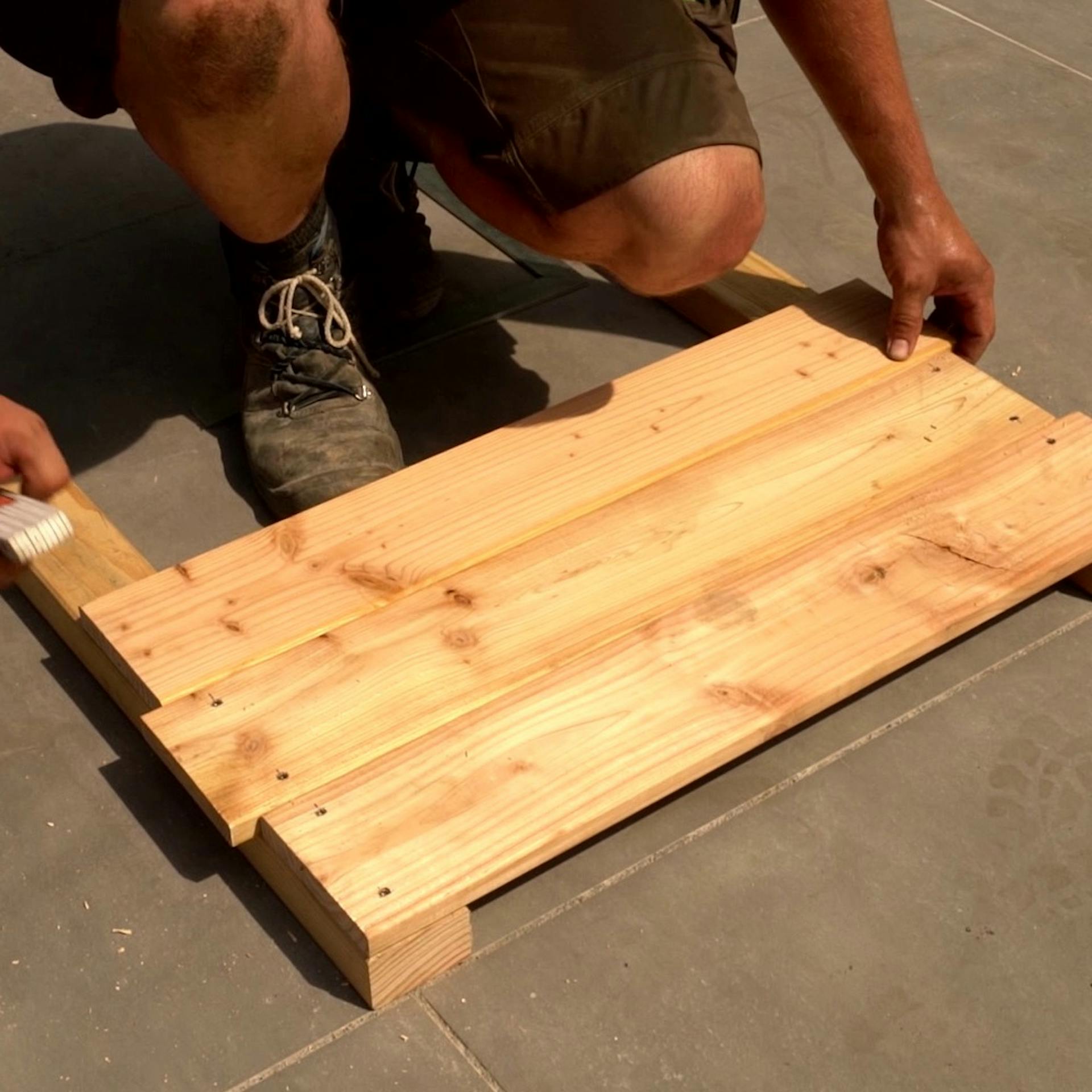 Heimwerker beginnt, Kopfteil für Hochbeet zu bauen.