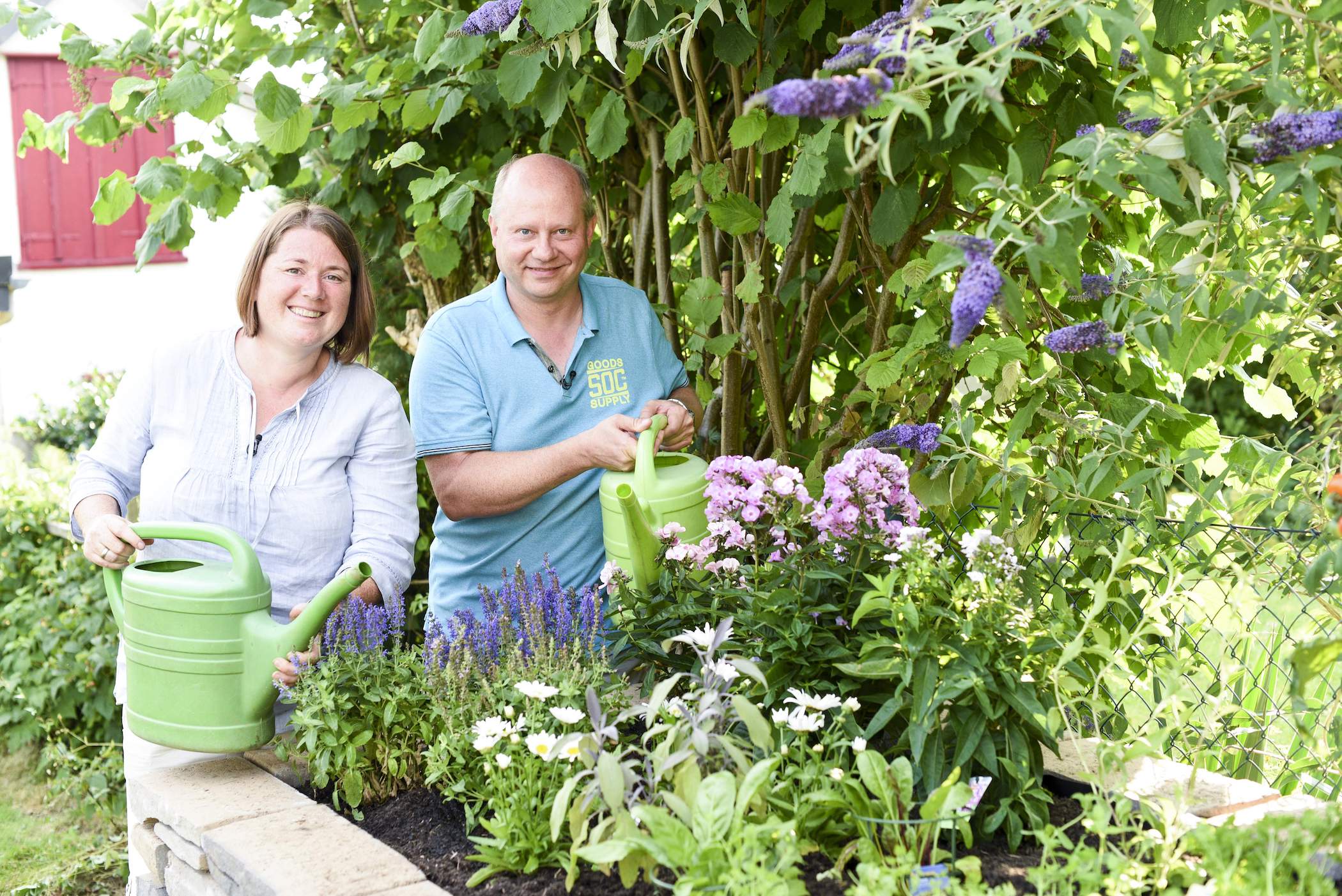Mann und Frau stehen hinter Hochbeet
