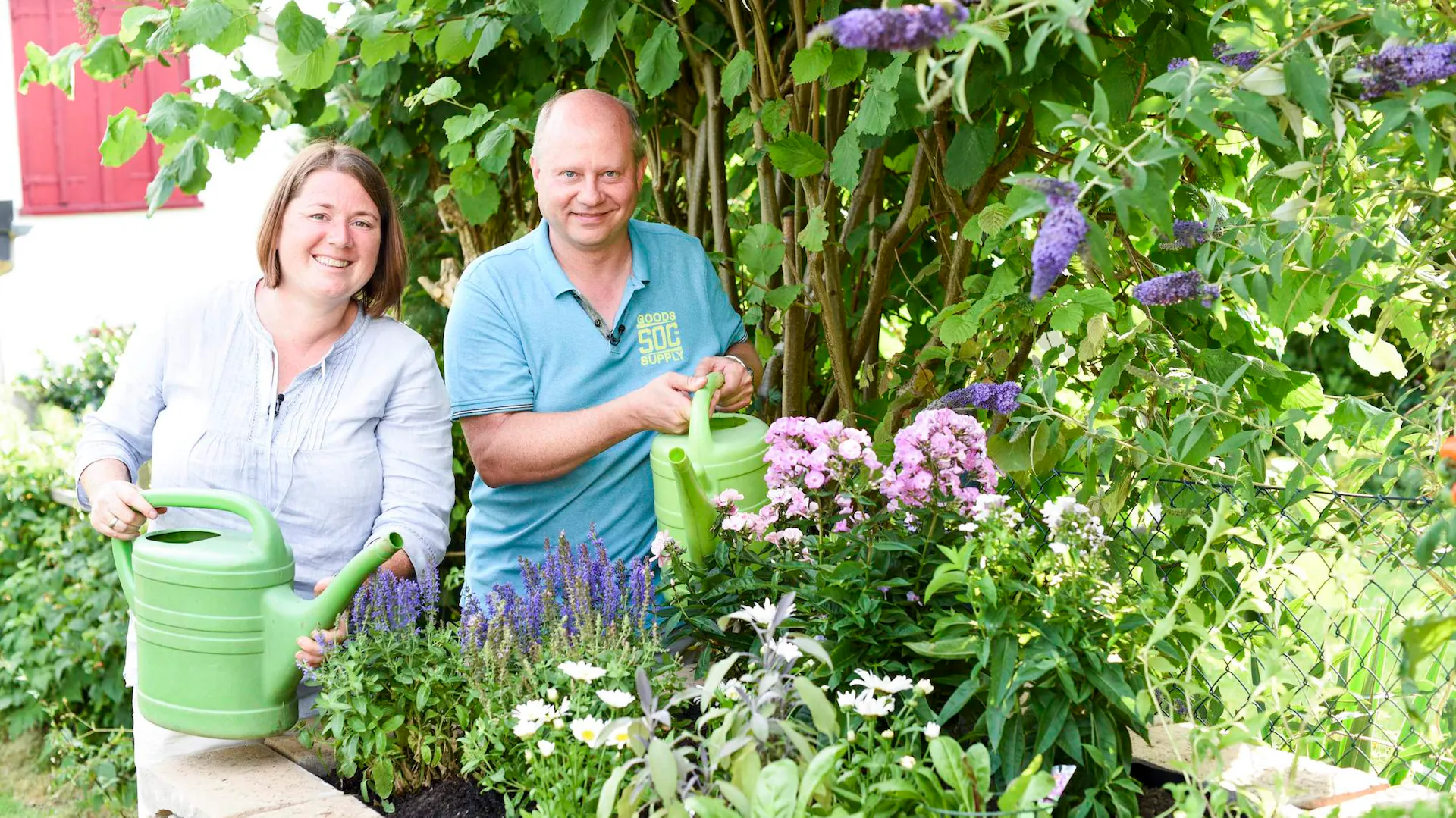 Mann und Frau stehen hinter Hochbeet