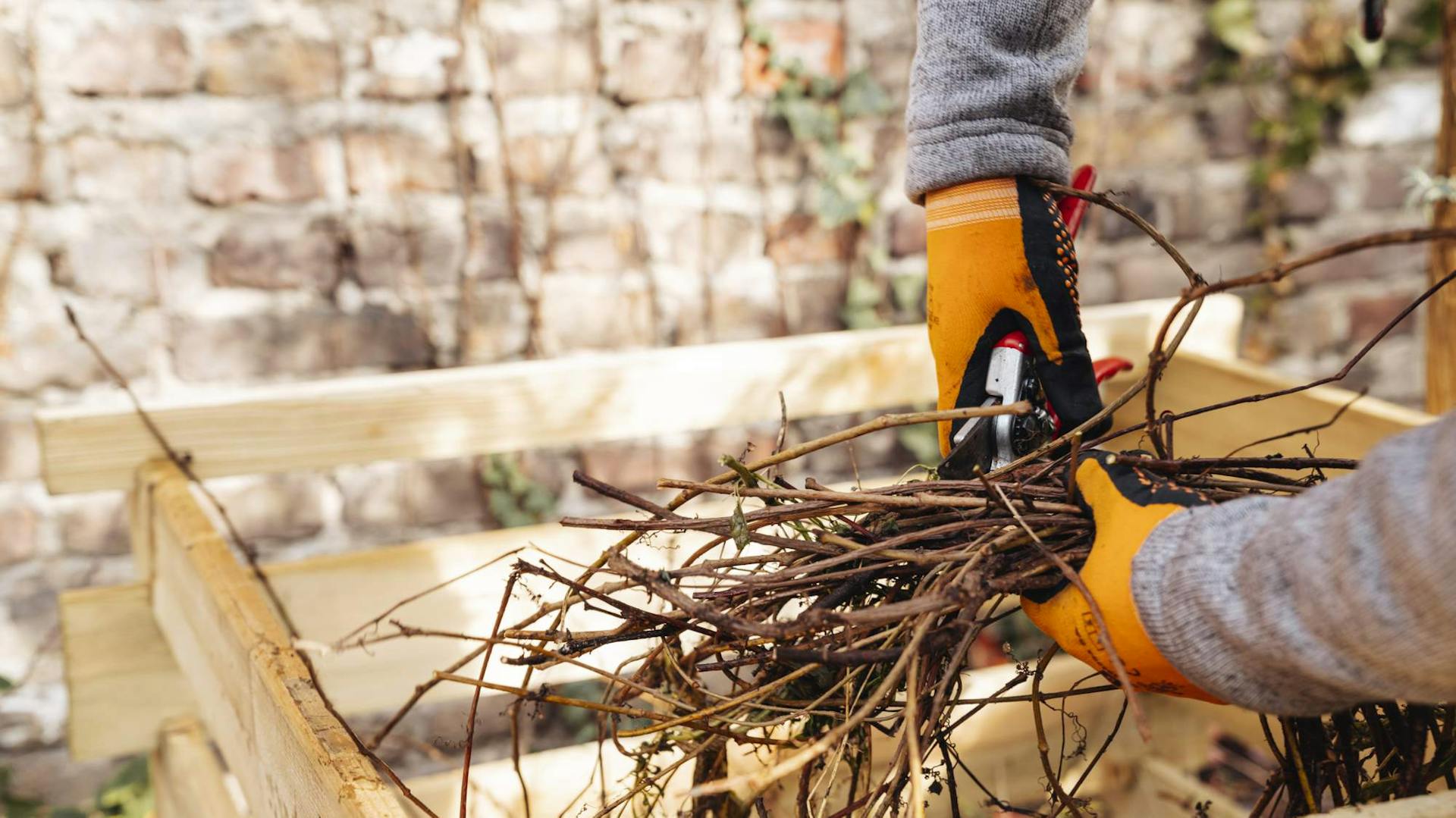 Man schneidet Äste um den Kompost umzusetzen