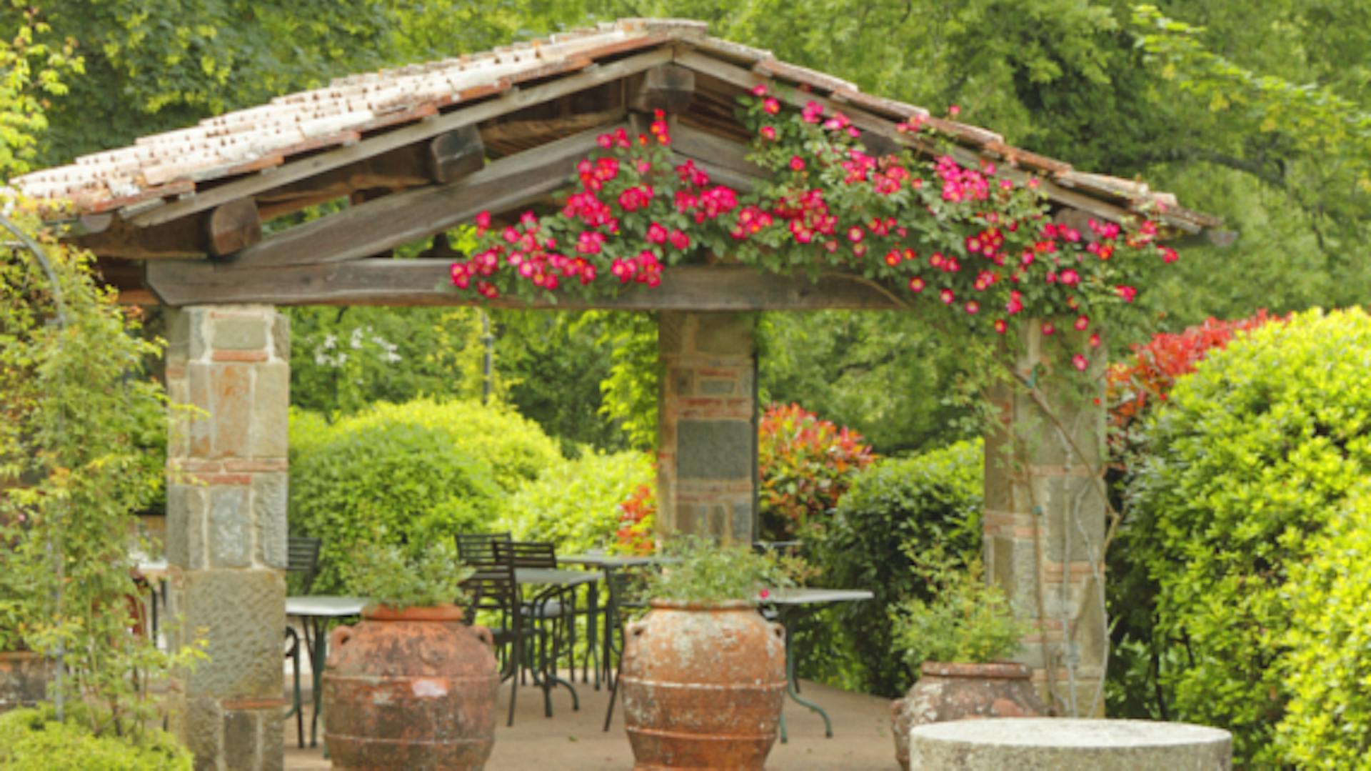 Mediterraner Garten mit mediterranem Pavillon in antikem Stil und vielen Pflanzen